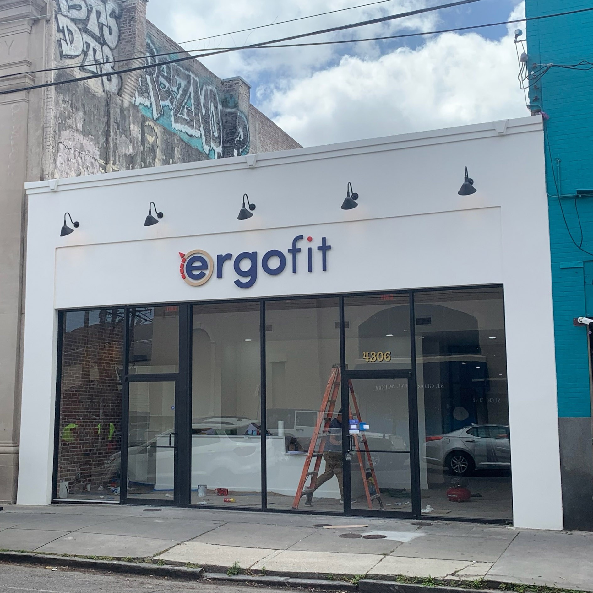Photo of an exterior facade of one story retail space with the logo saying "ergo fit" above the storefront's large glass windows 