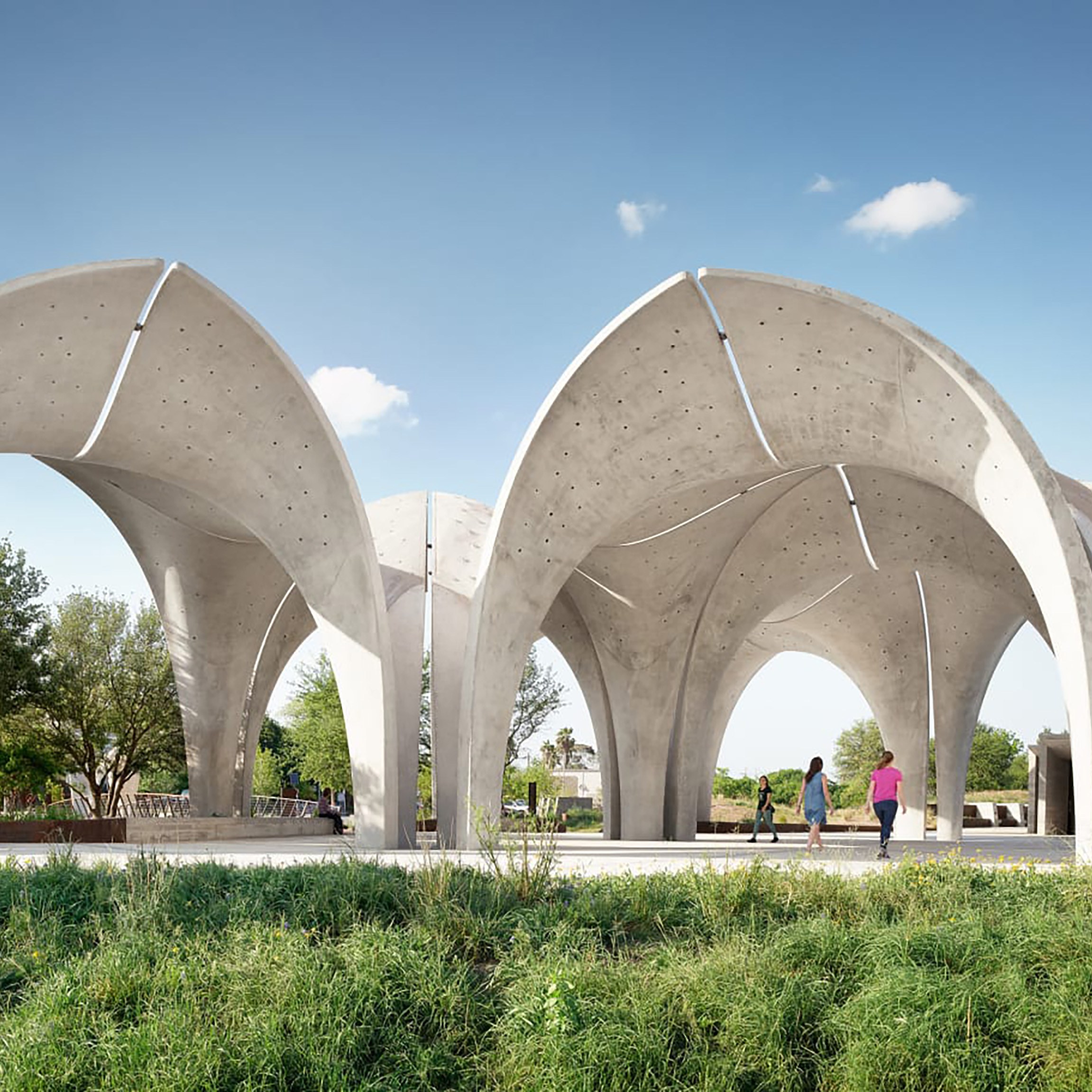 Photo of Confluence park, with greenery in the front of the image and large arches