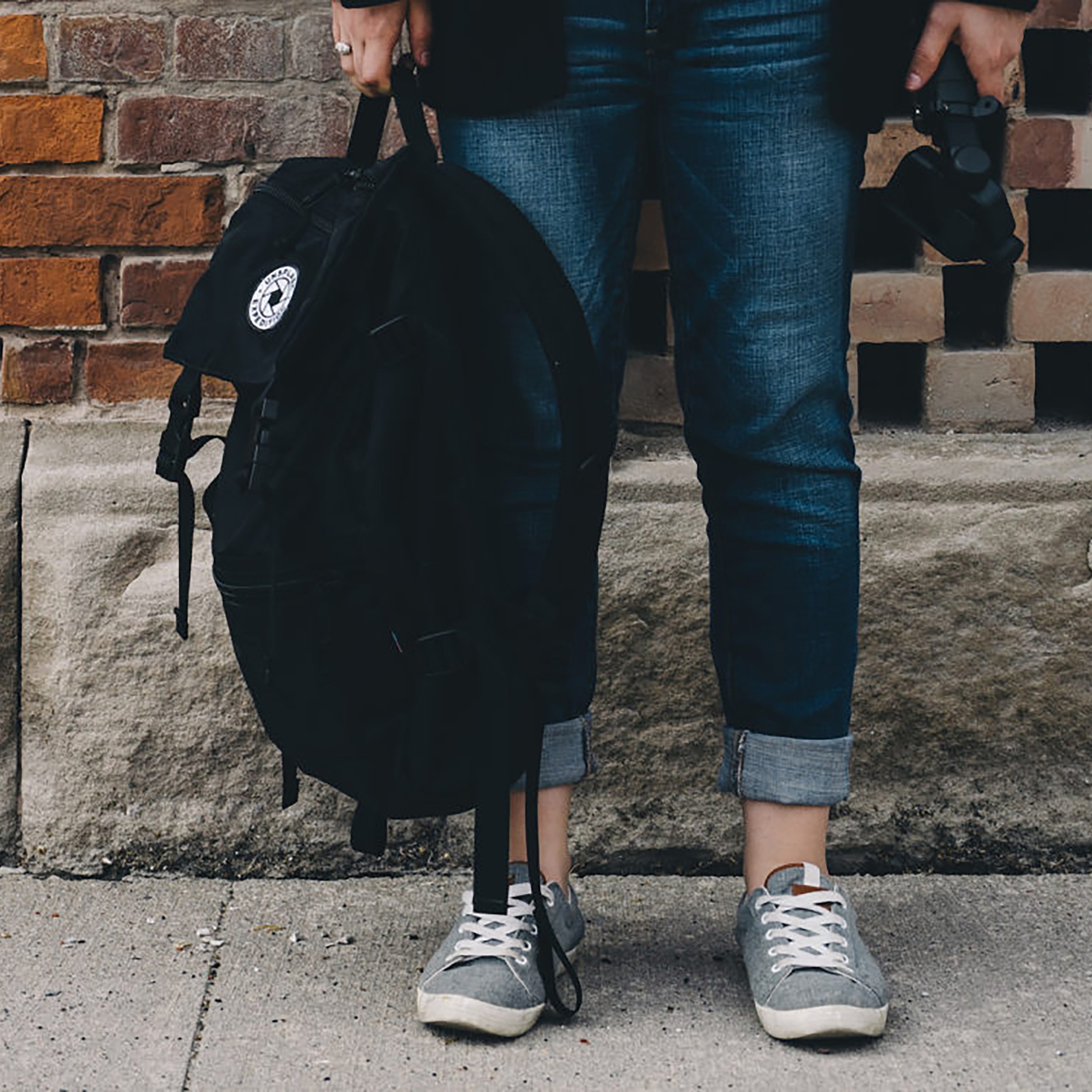 Photo of the legs of someone holding a backpack