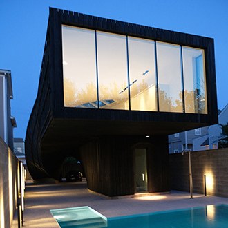 Photo of exterior of modern home with floor to ceiling windows