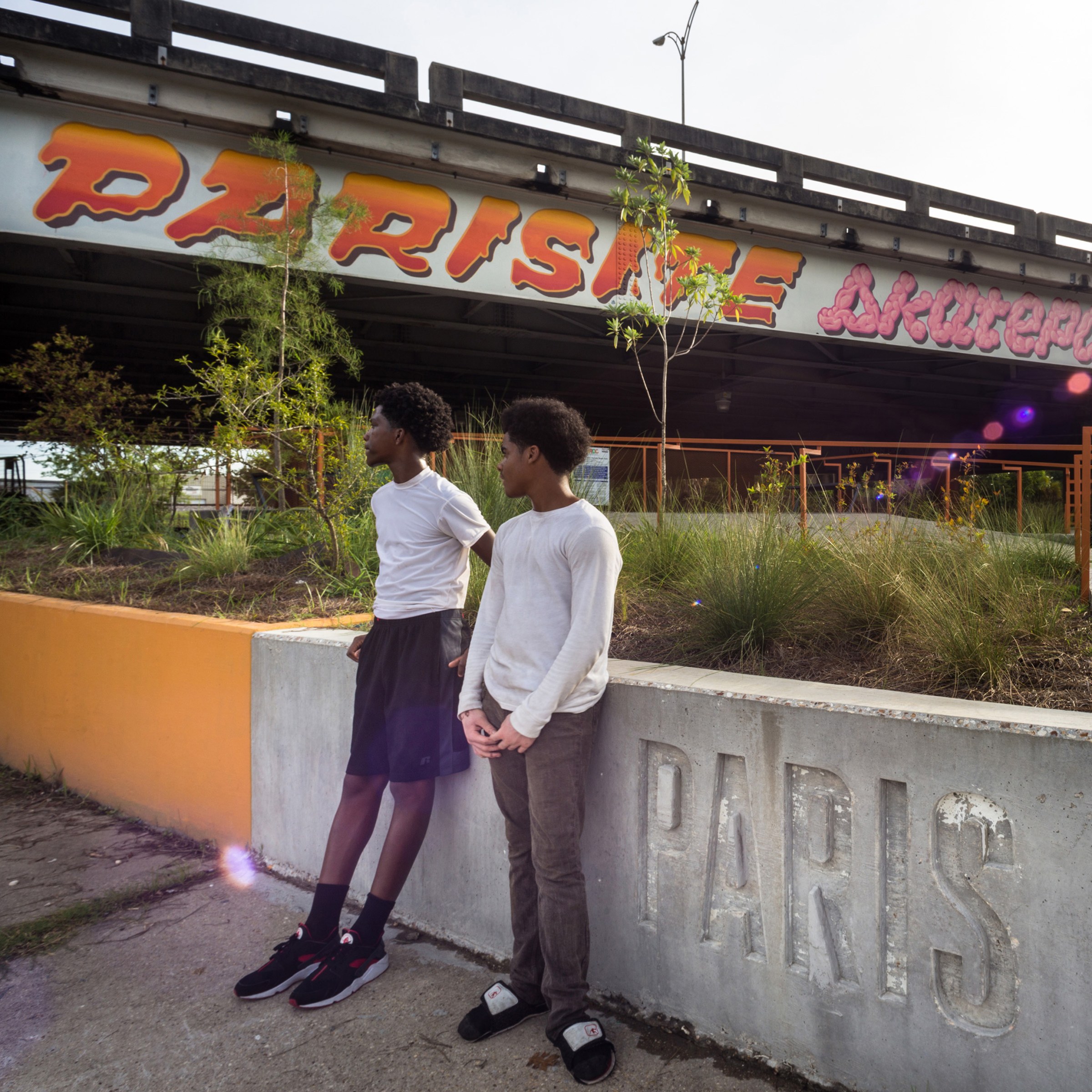 Two young boys standing in front of concrete wall at Parasite Skatepark