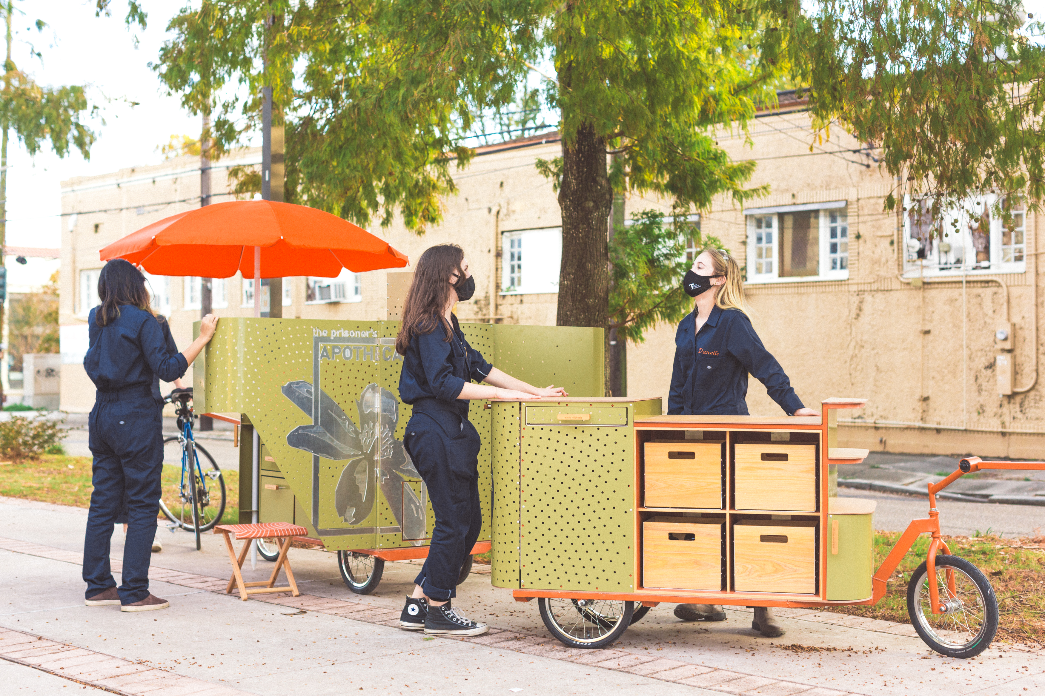 Photo of a group of students using the drawers and features of two bike-drive carts, called apothecarts.
