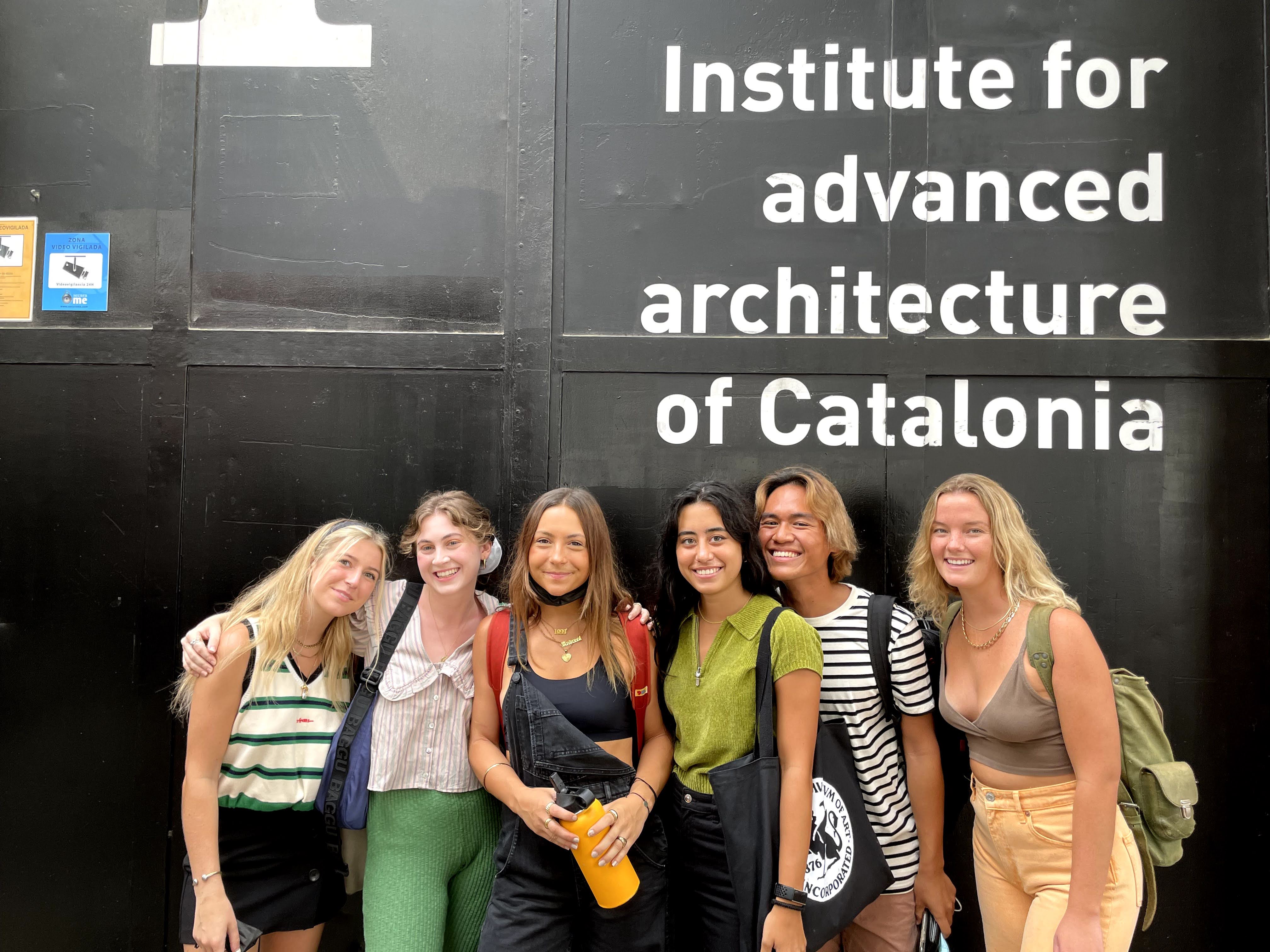 Photo of a group of study abroad students standing in front of a wall that says "Institute for advance architecture of Catalonia"