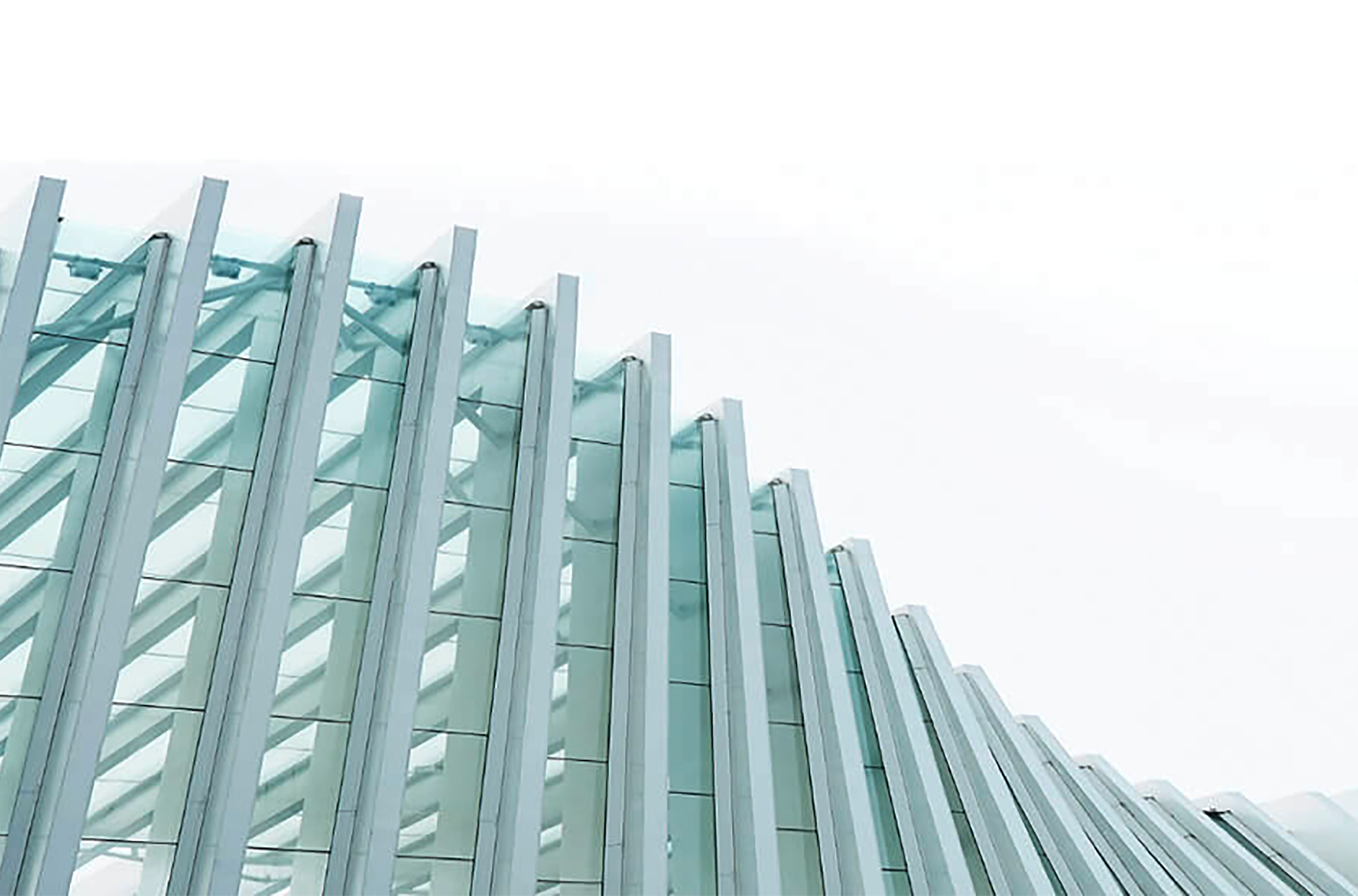 Photo of a curved building facade with beams and windows, looking up to the sky from below the curved structure
