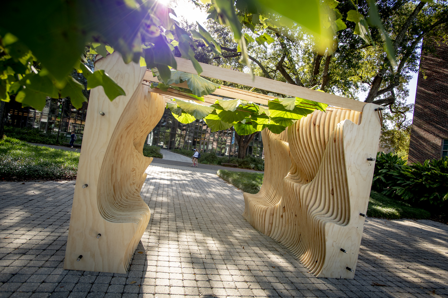 Photo of an outdoor Sukkah, small pavilion, built from vertical wood panels with the interior sides of panels cut in wave-like patterns