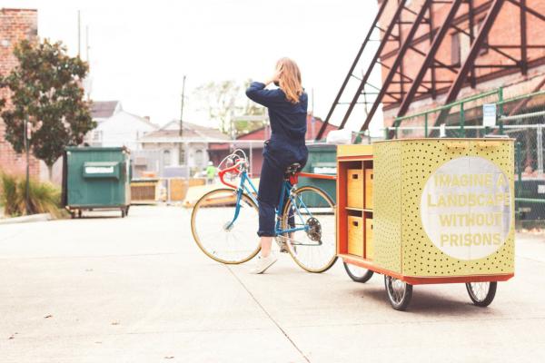 Yellow "apothecart" being pulled person on bike 