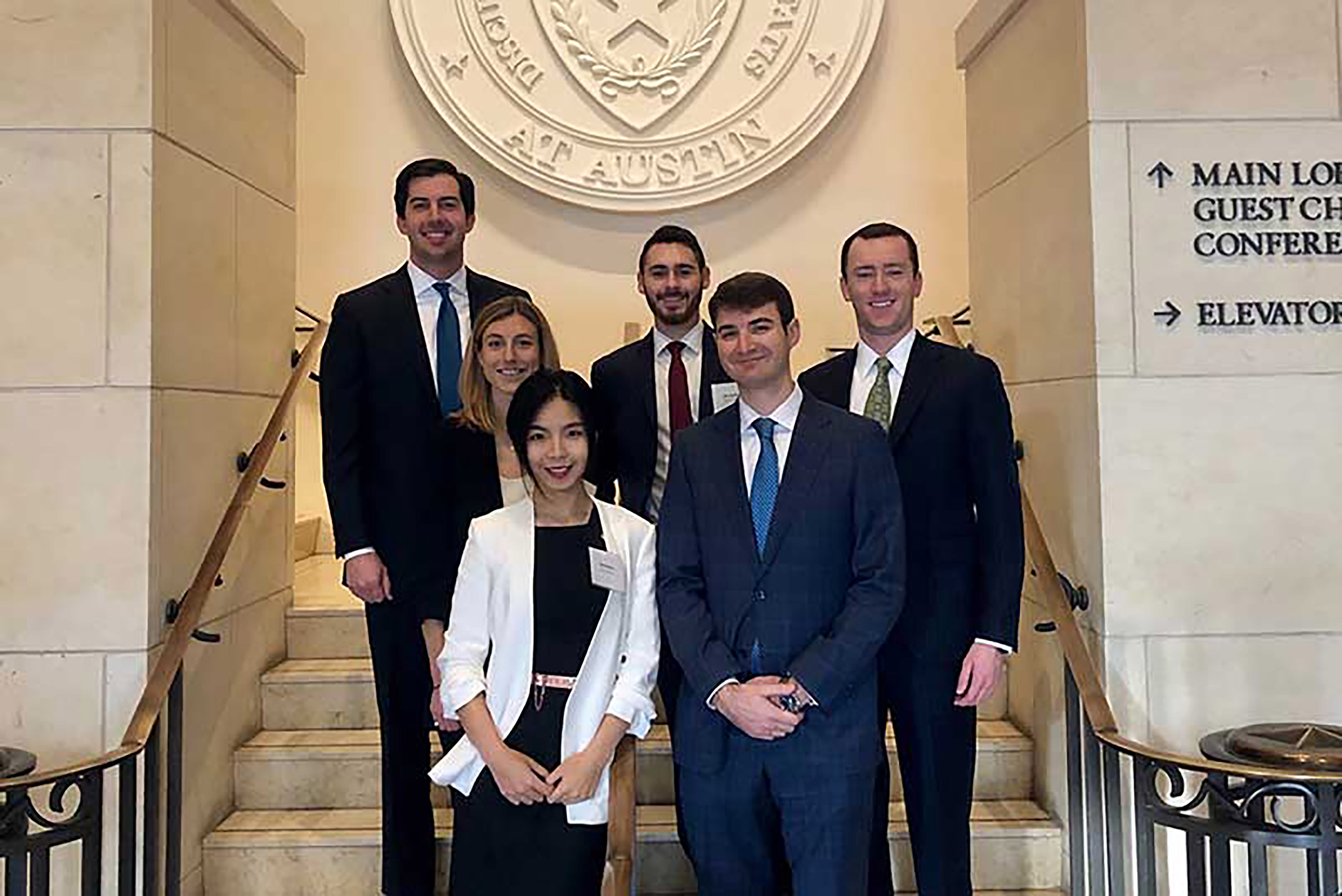 Photo of six students posing on marble staircase