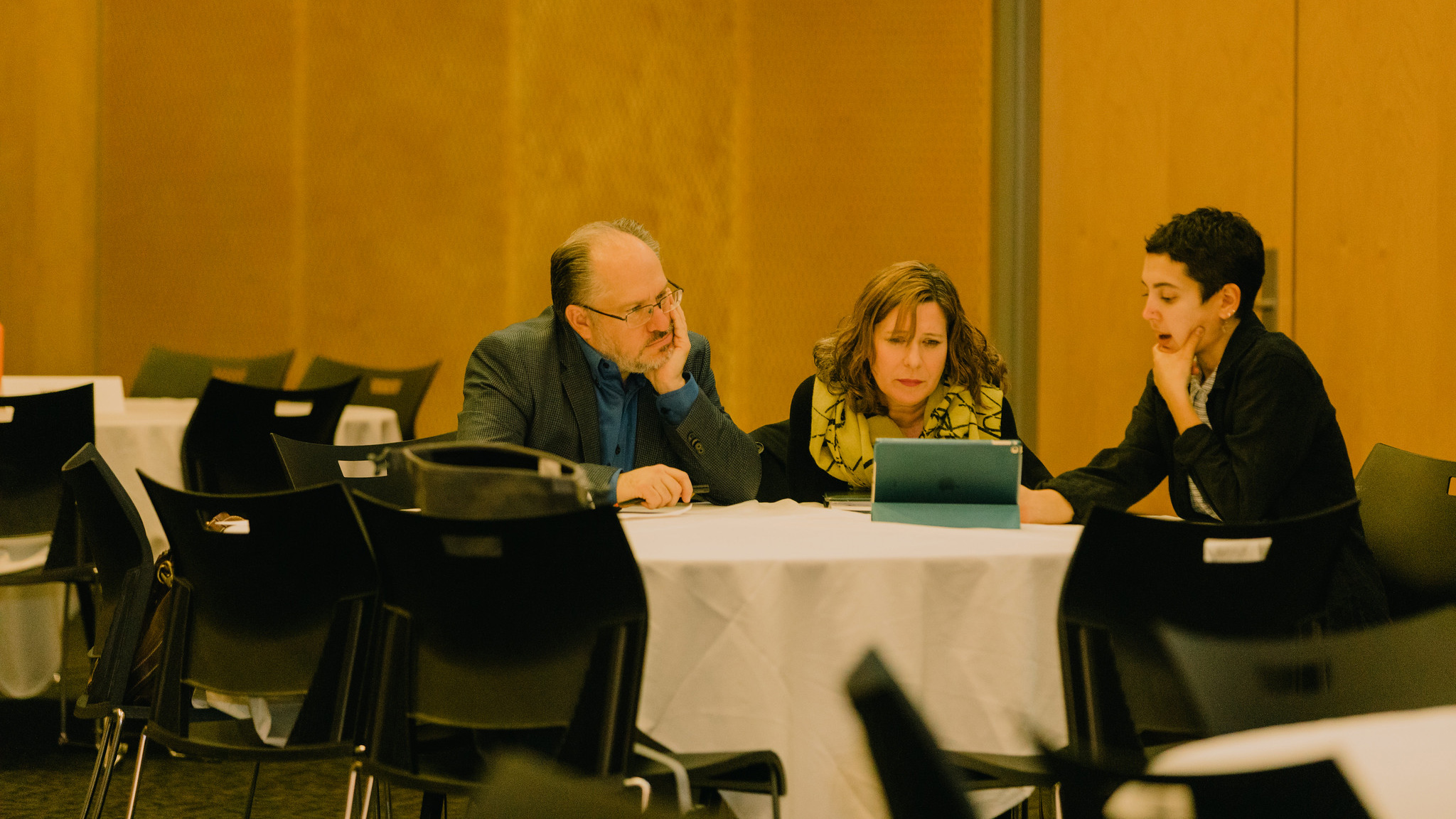 student sits with architecture and design firms, looking over a portfolio on the table