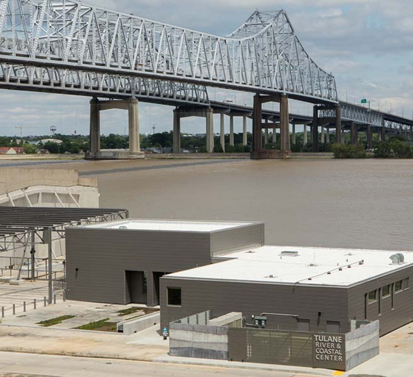 Aerial view of the Tulane River and Coastal Center, located along the Mississippi River with the Crescent City Connection bridge over the river in the background.