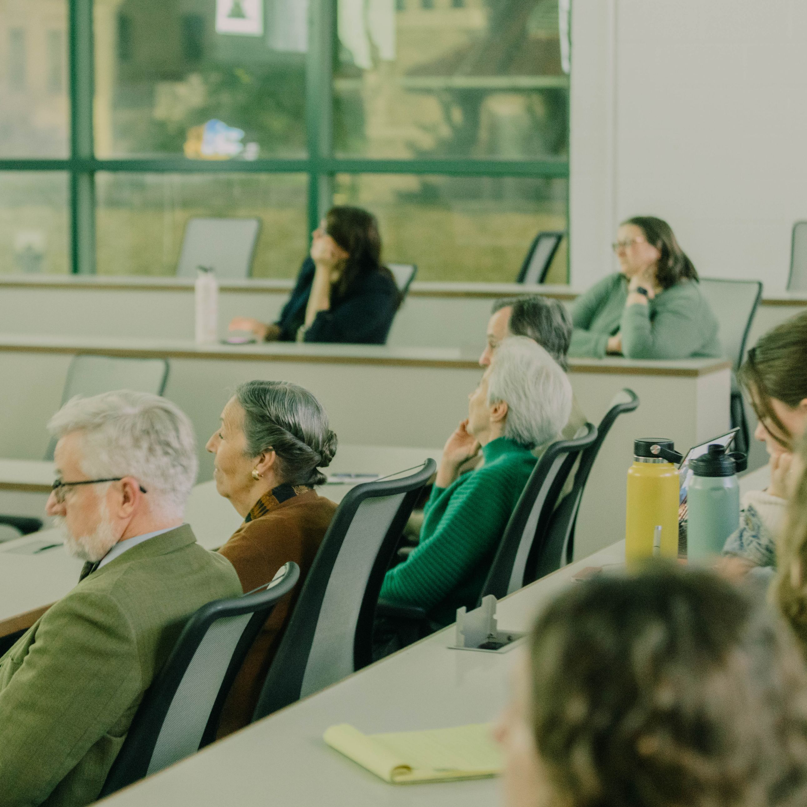 People sitting in a room listening to a speaker