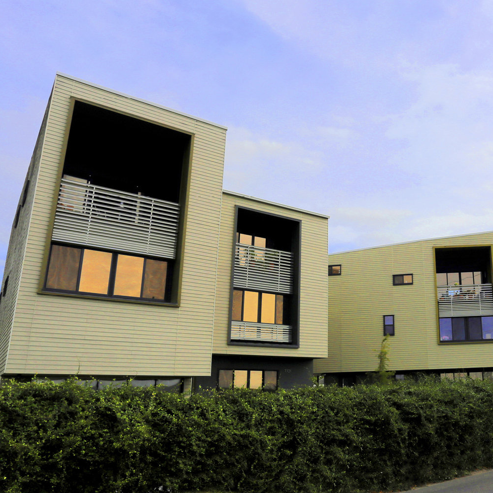 image of tan building with blue skies and greenery