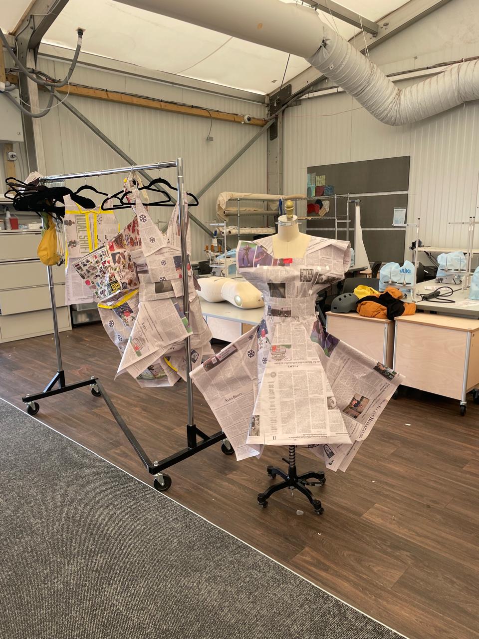 Photo of projects in the textile lab. Newspaper fashioned as clothing on hangers and a mannequin