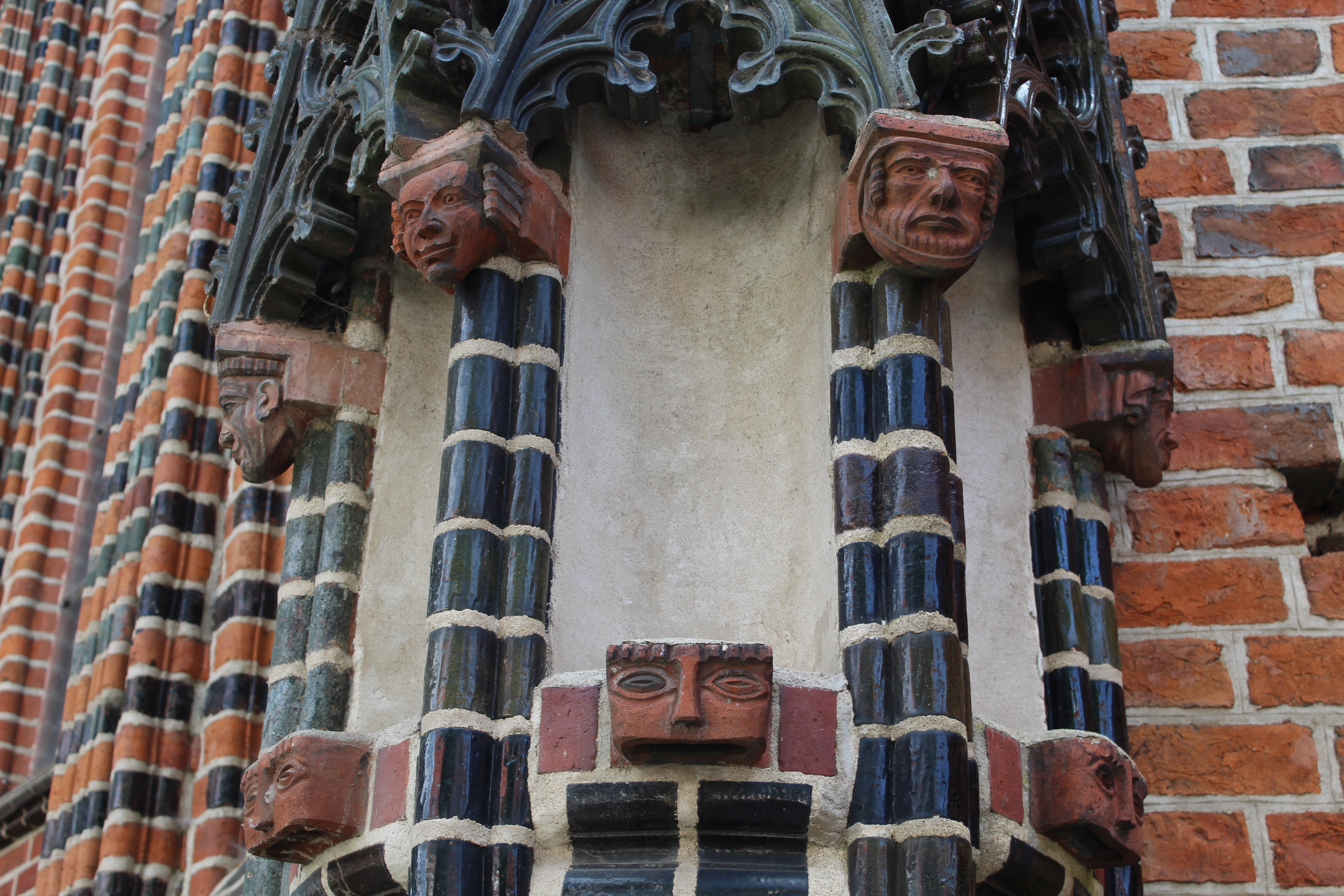 A zoomed in image of the side of a building, brick gothic architecture