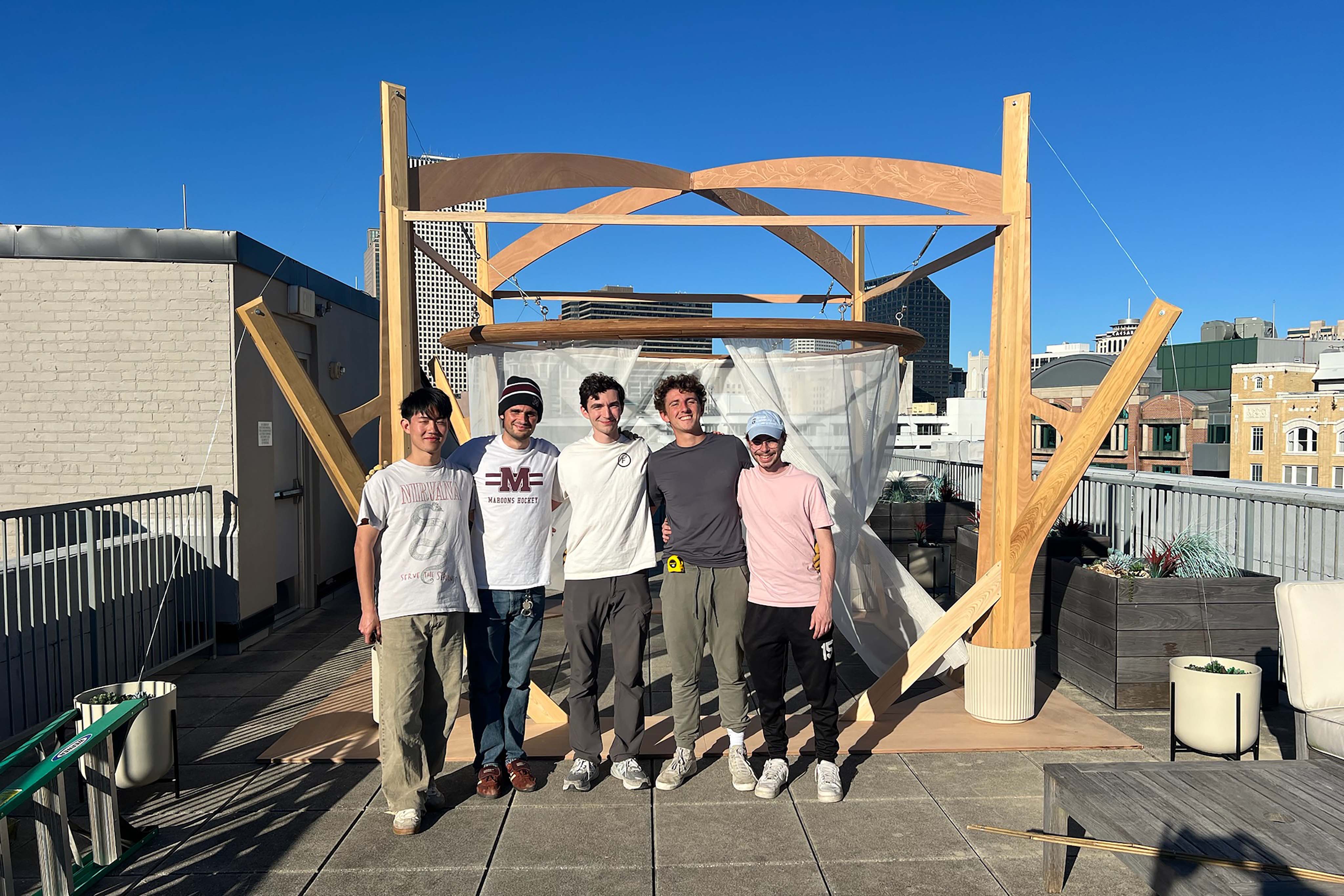 Students standing in front of a Sukkah. 