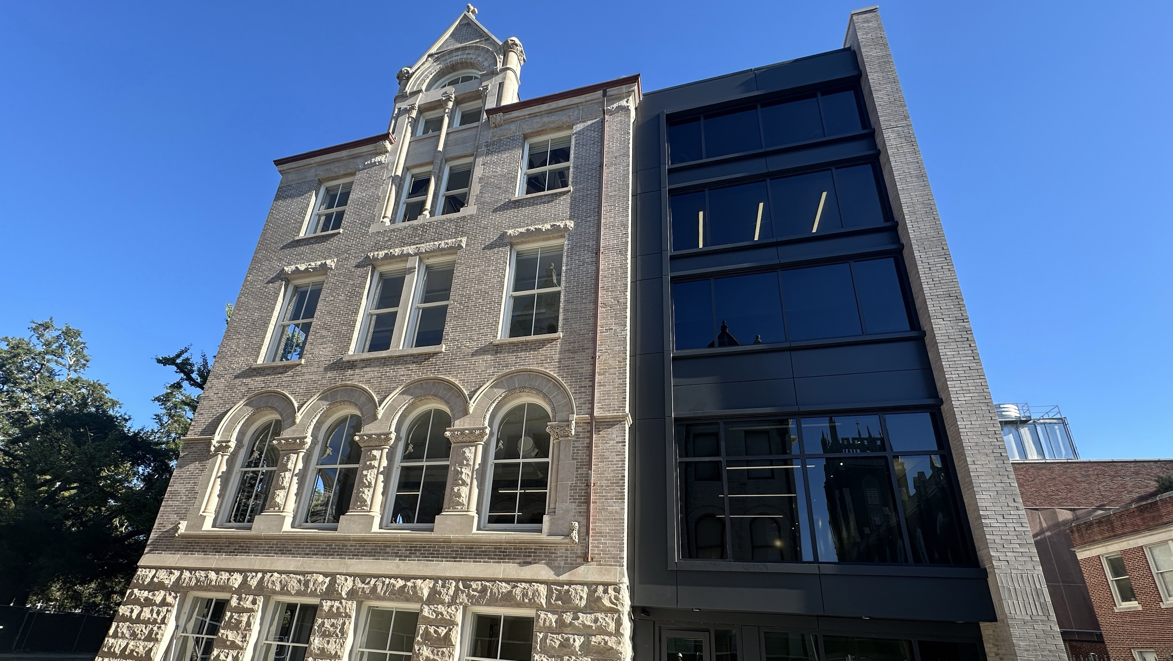View looking up at north facade of Richardson Memorial Hall's renovation with addition on the right and original historic building on the left.
