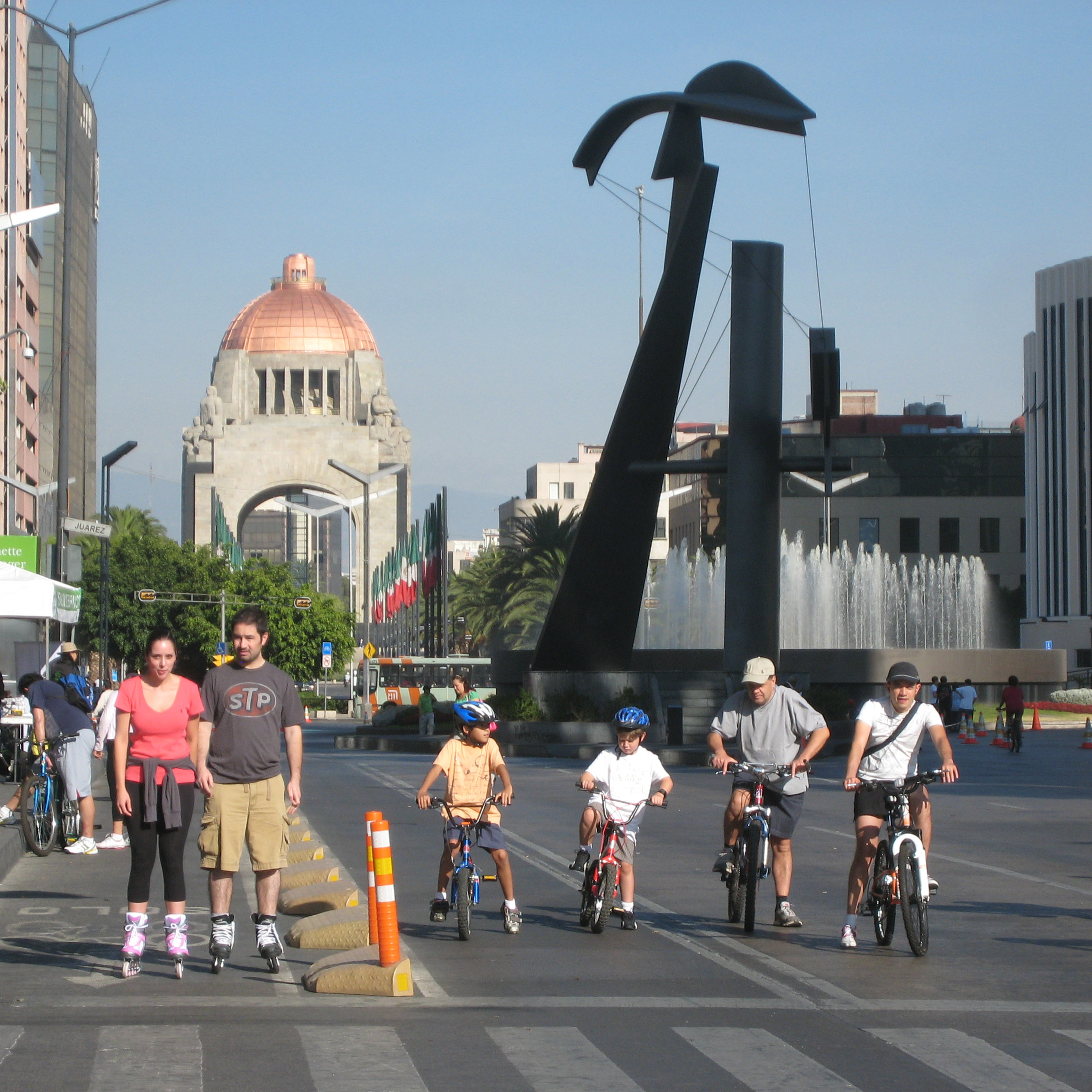 People at a city street intersection showing bike and pedestrian transit.