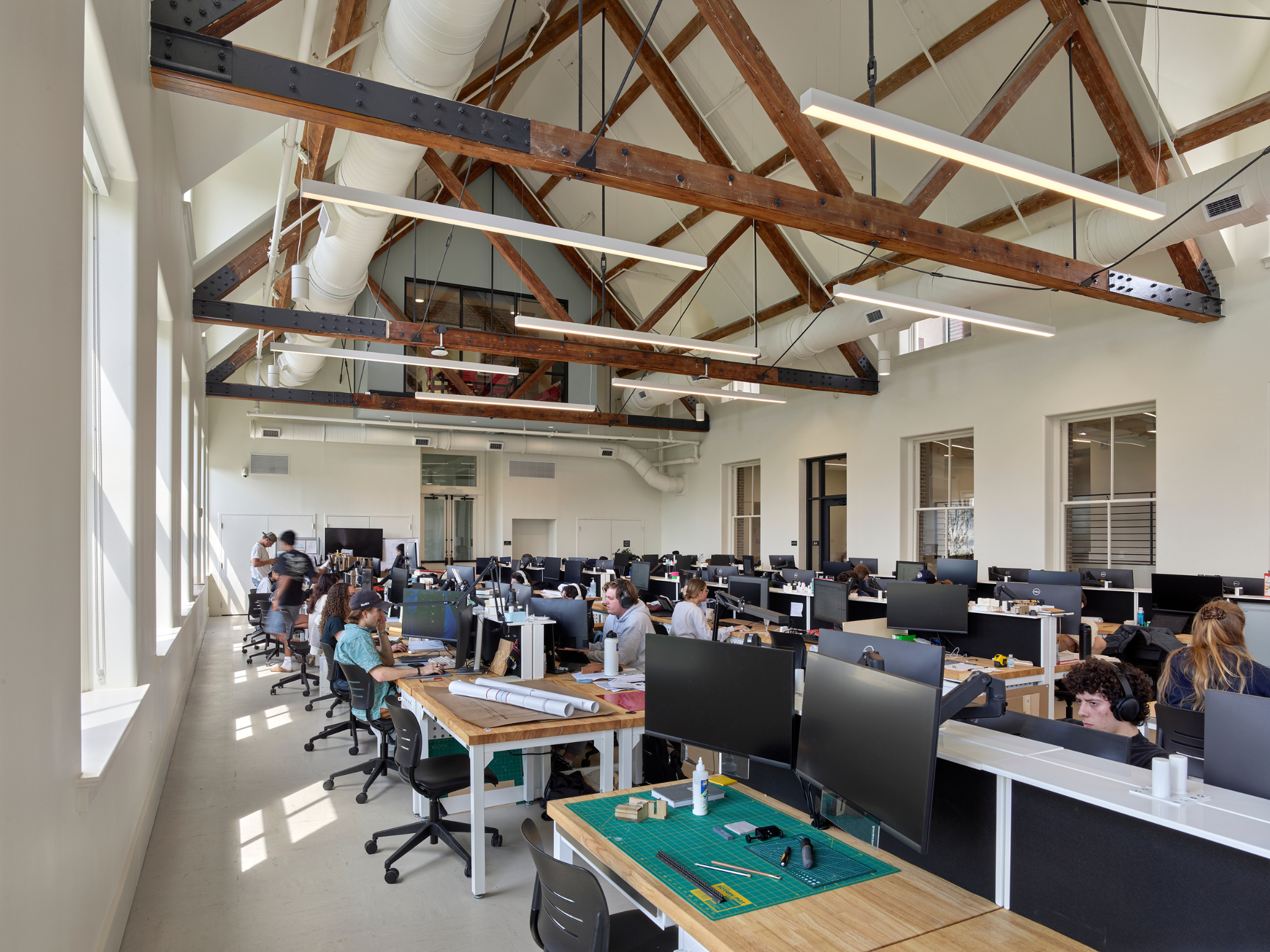 Insider corner view of a large studio with a vaulted ceiling and exposed wood rafter beams inside Richardson Memorial Hall.