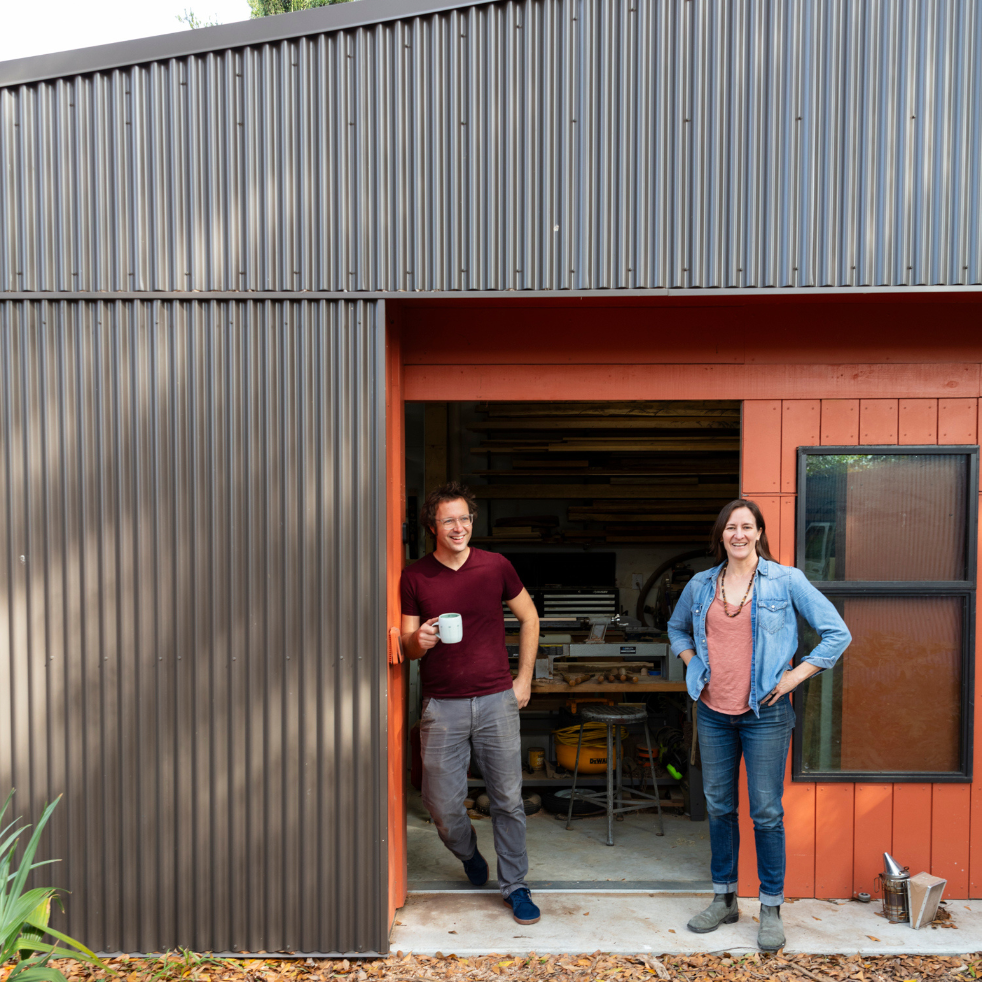 Environmental portrait of Colectivo's Seth Welty and Emilie Taylor Welty, both alumni, standing outside their home woodshop.