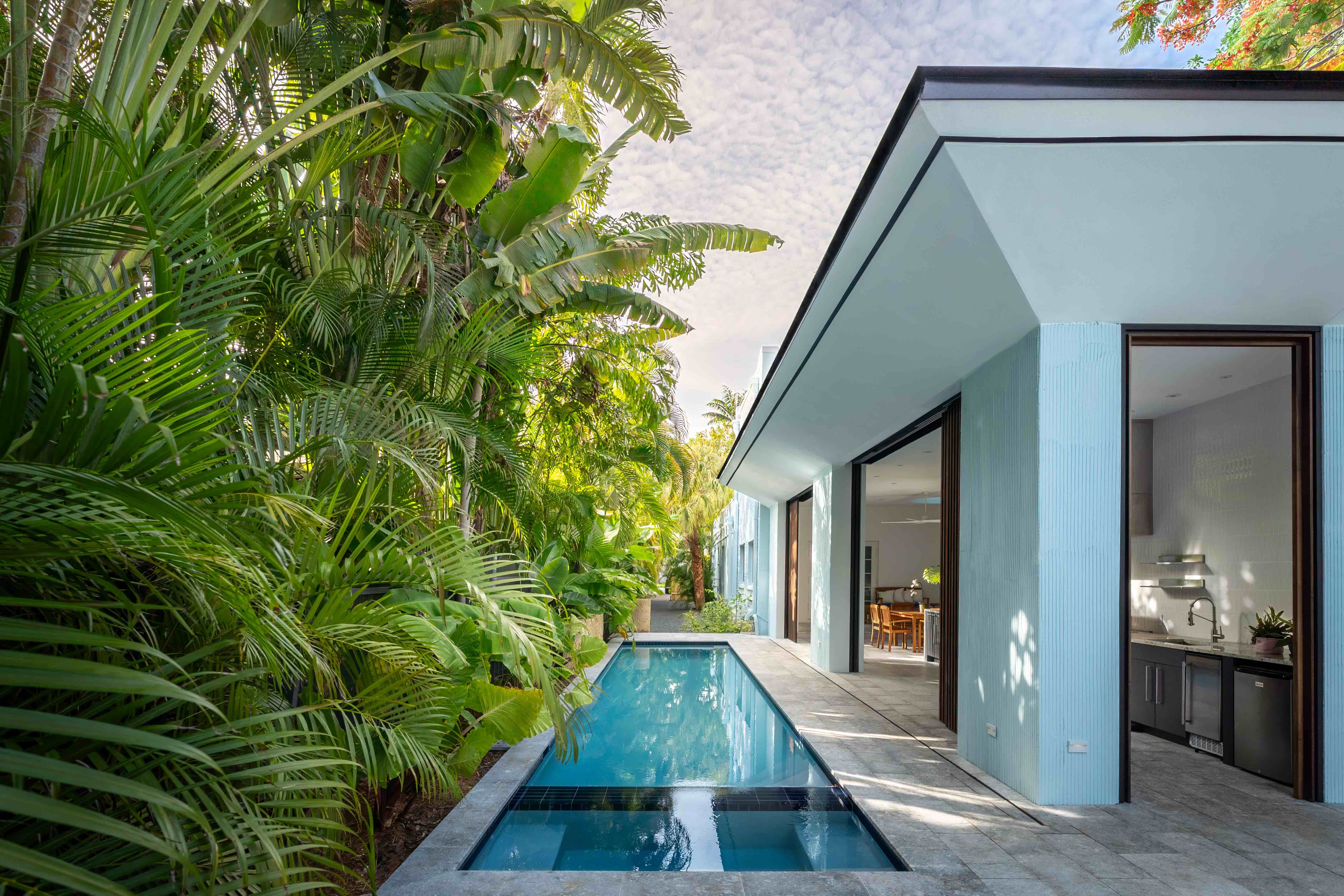 Outdoor/indoor kitchen and pool at residential home in Miami designed by Atelier Mey