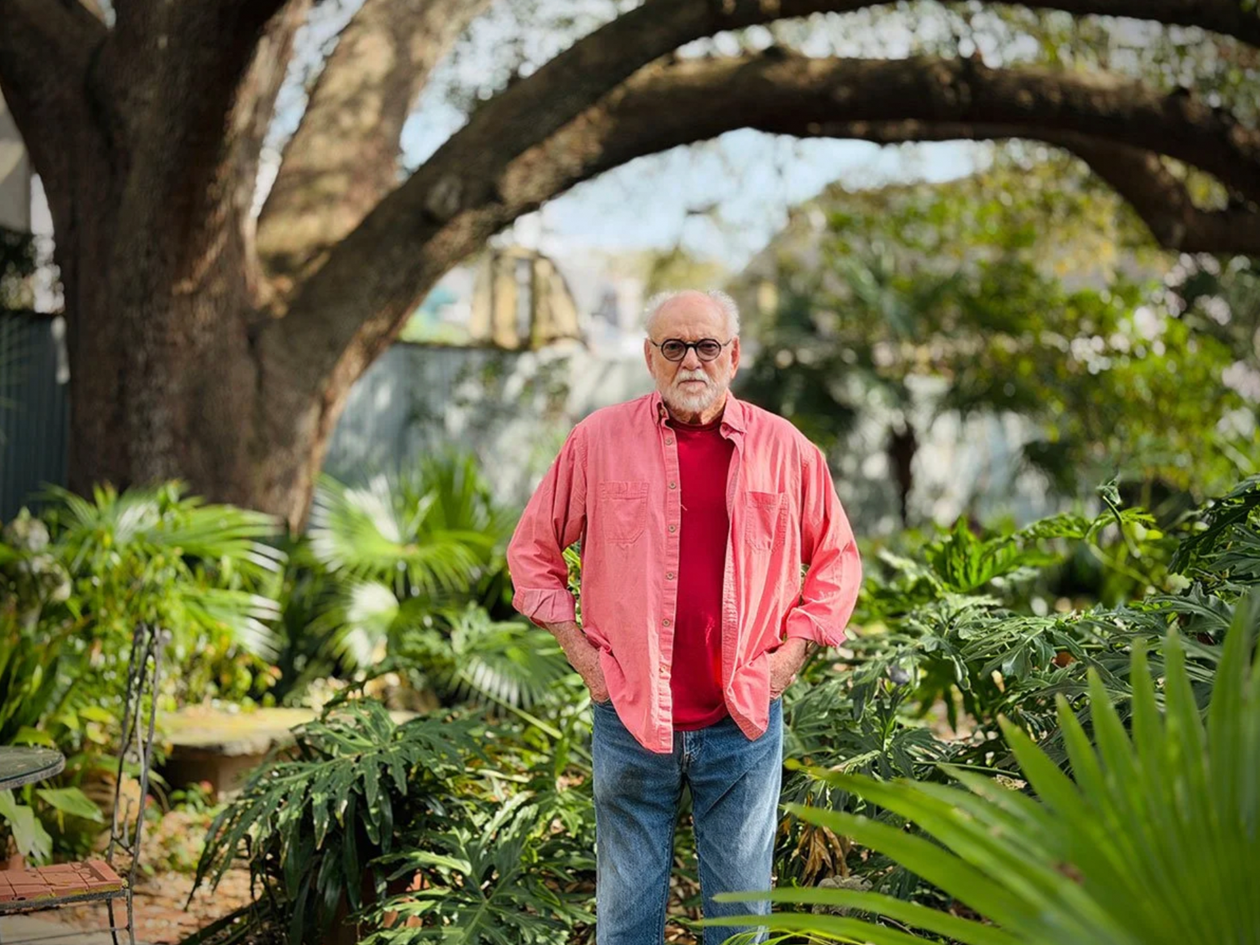 Picture of Gene Cizek standing next to foliage under an oak tree with his hands in his pockets