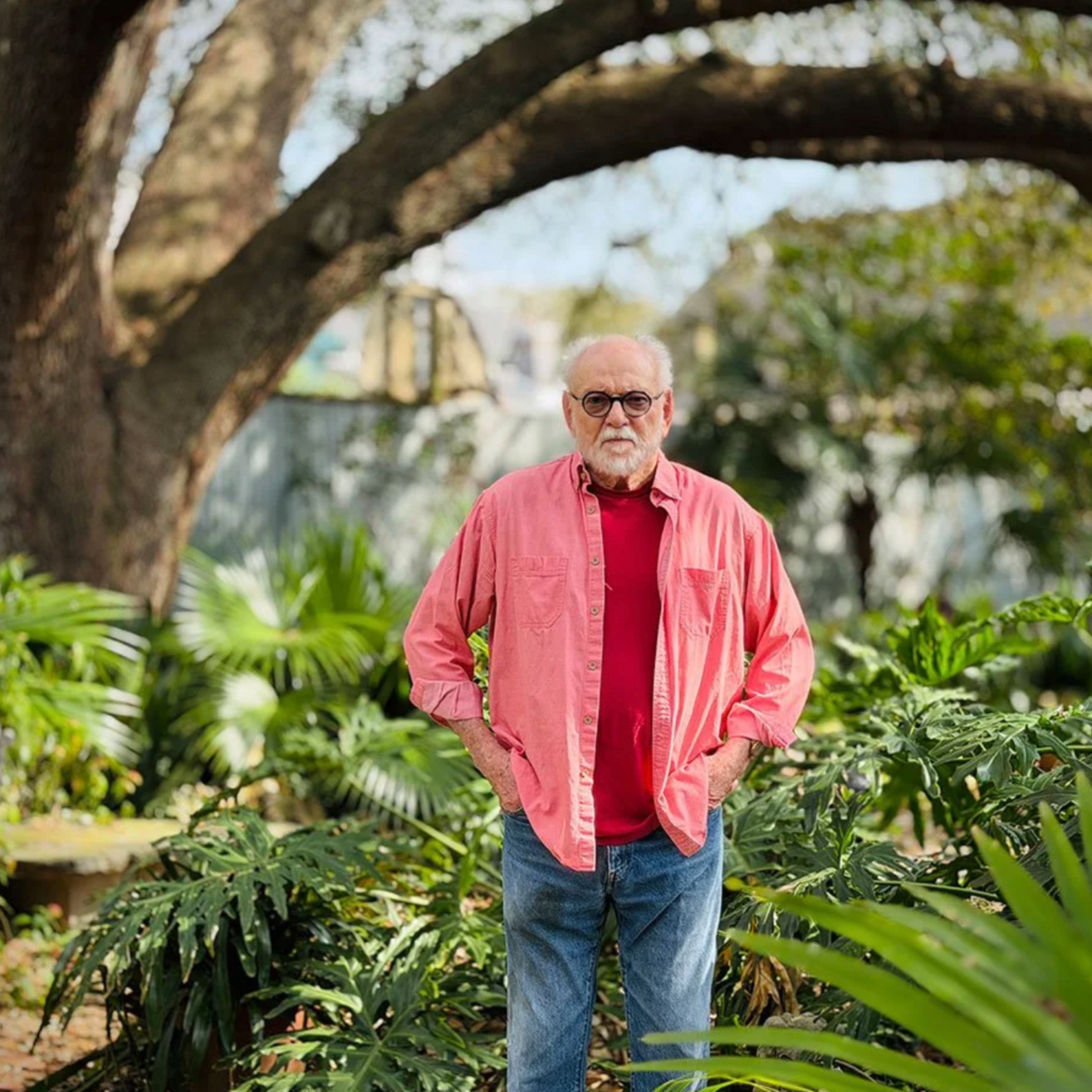 Picture of Gene Cizek standing next to foliage under an oak tree with his hands in his pockets