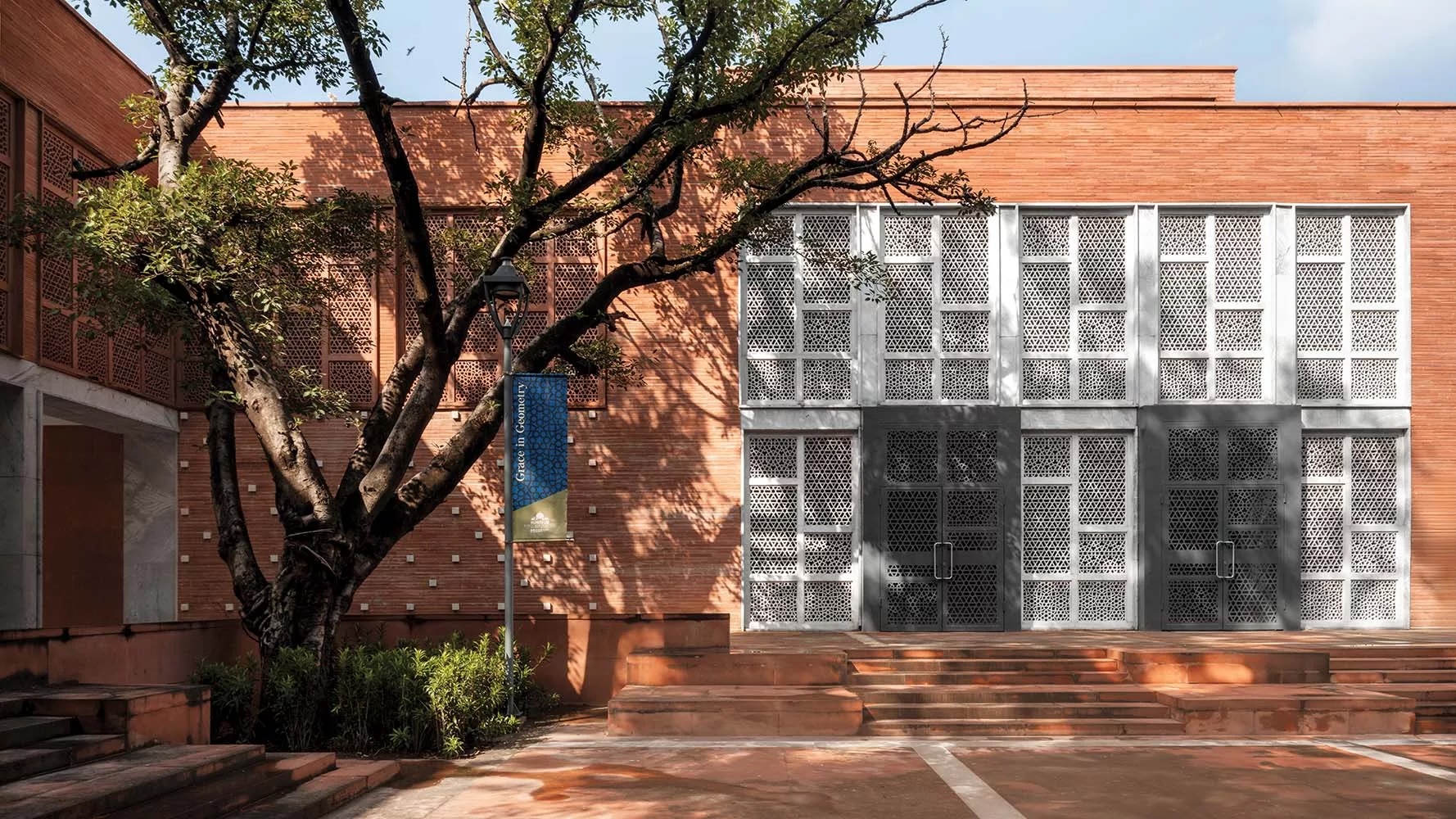 A museum in red brick shaded by trees