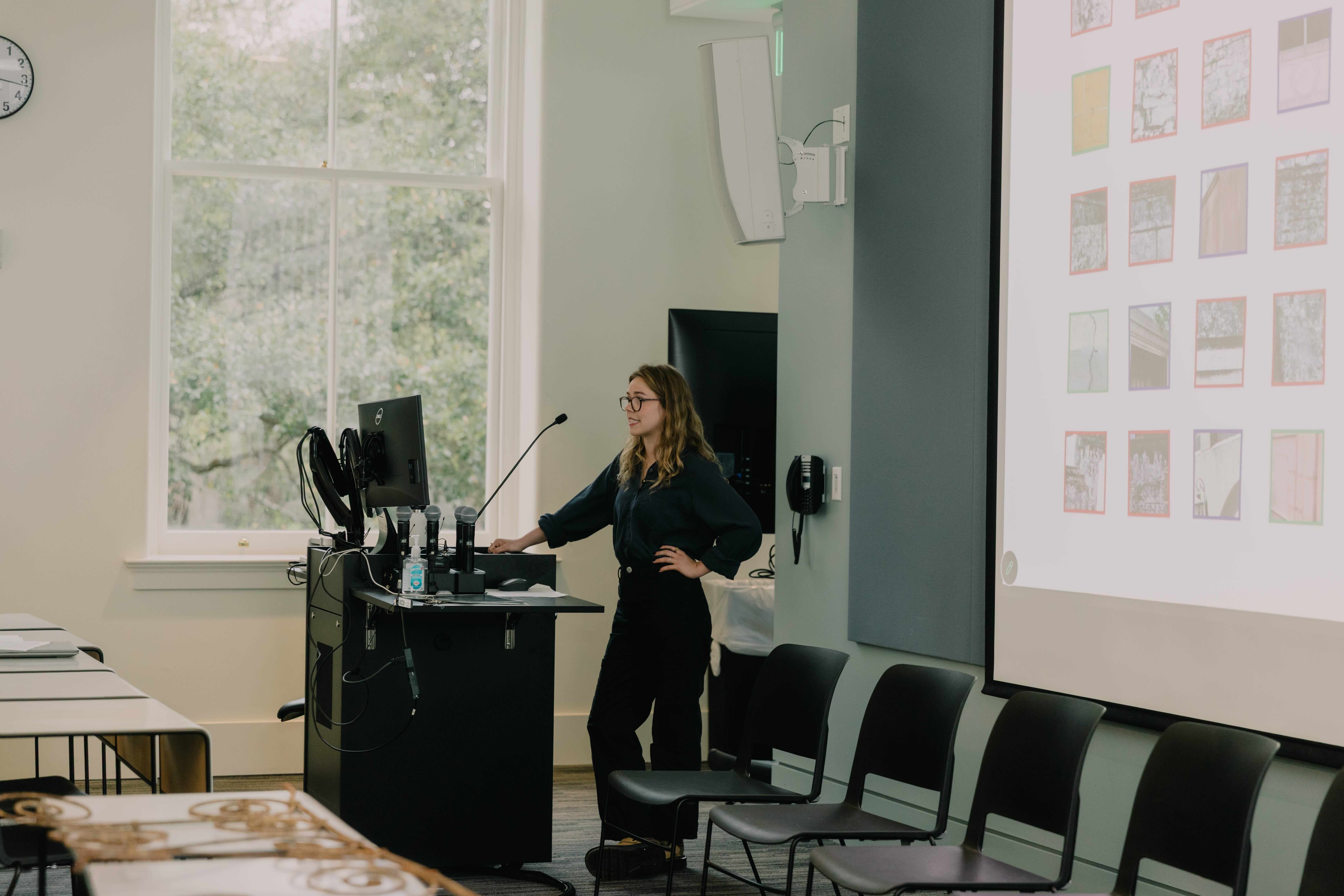 student presents in front of a slideshow