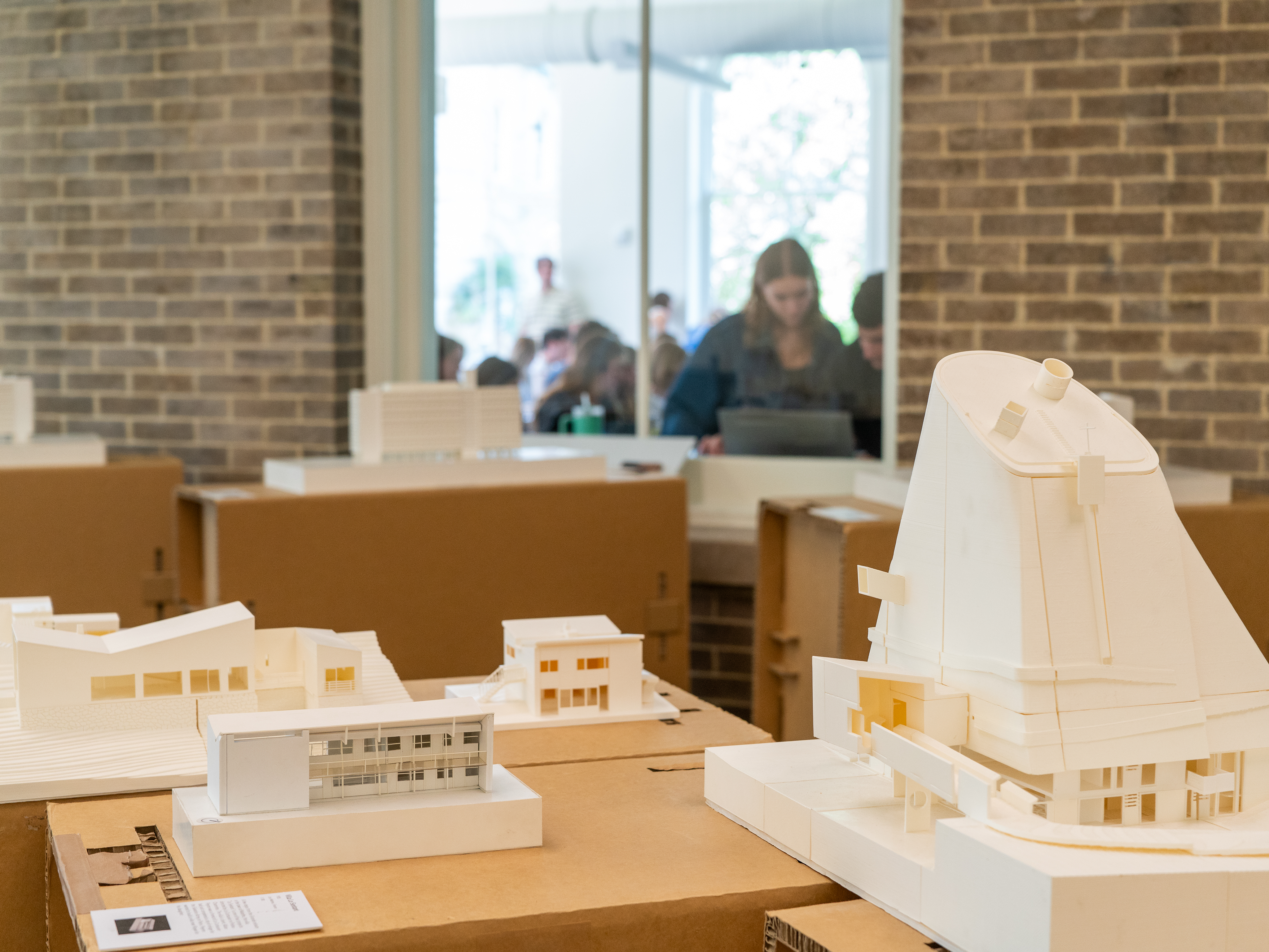 Students looking at display of models through a window