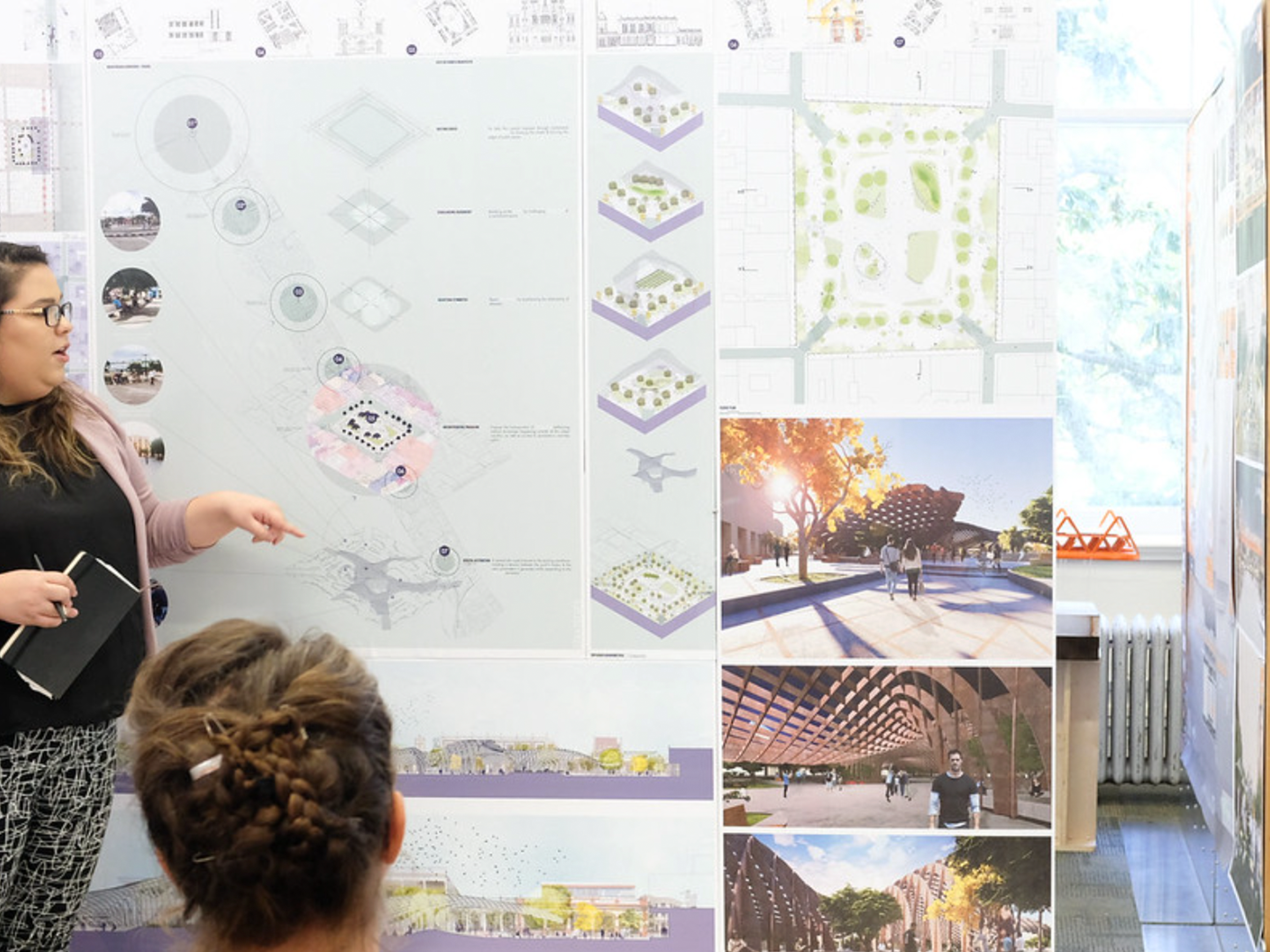 Presenter lecturing in front of poster, audience member watching