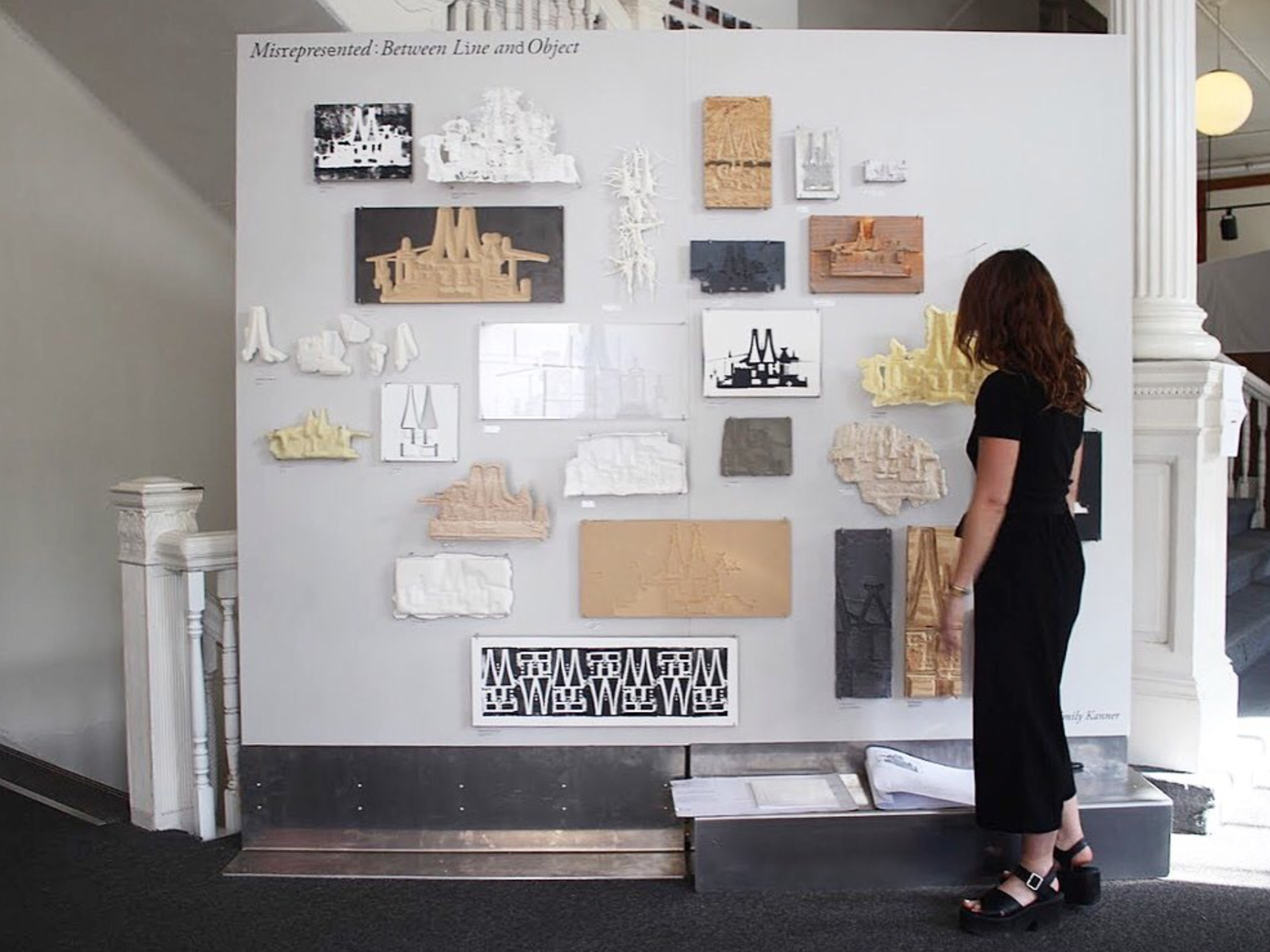 Woman in all black clothing facing presentation board 