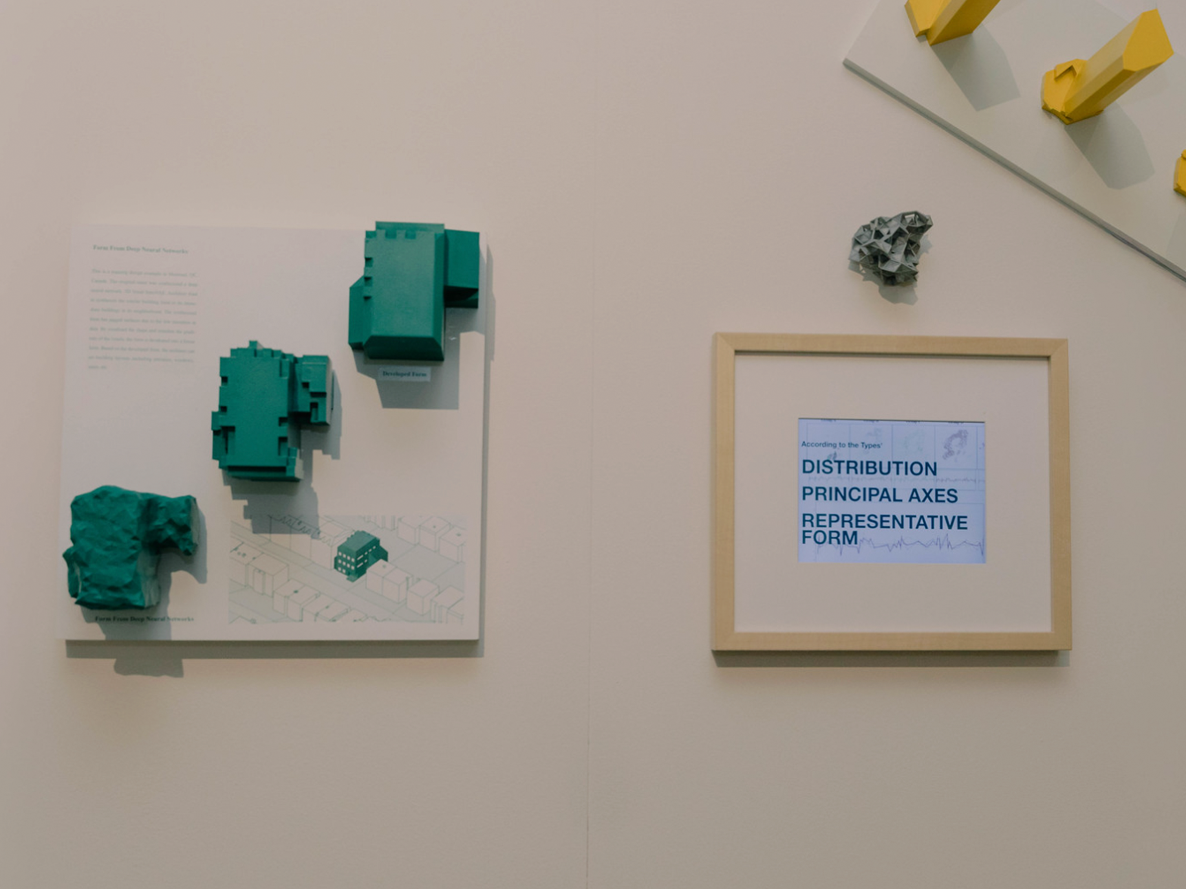 Close up of a green model on the left and a yellow model in the top right with a sign that reads "DISTRIBUTION PRINCIPLE AXES REPRESENTATIVE FORM"