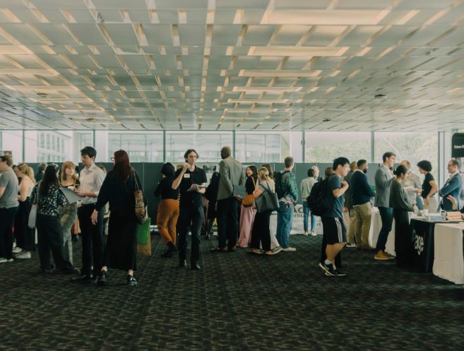 people walking around during a career day event. Some are talking to tables and others are walking around.