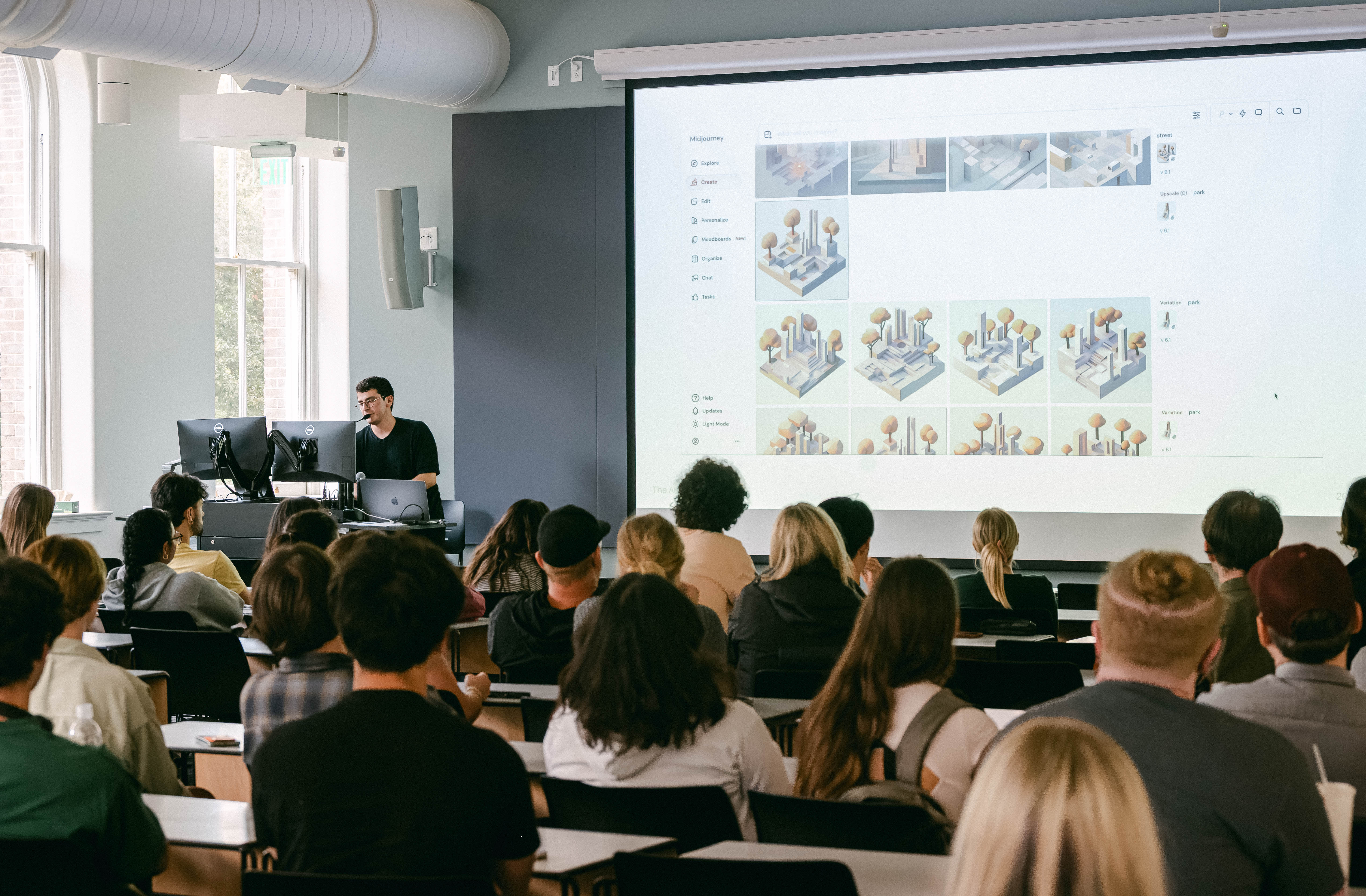 View from the back of a lecture hall while faculty Alper Turn presents "The Artificial City" to a seated audience.