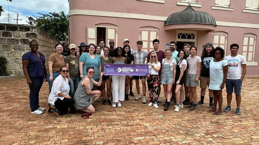 Large group of diverse students from US, UK, Caribbean pose together for a picture in front of a historic building in Barbados