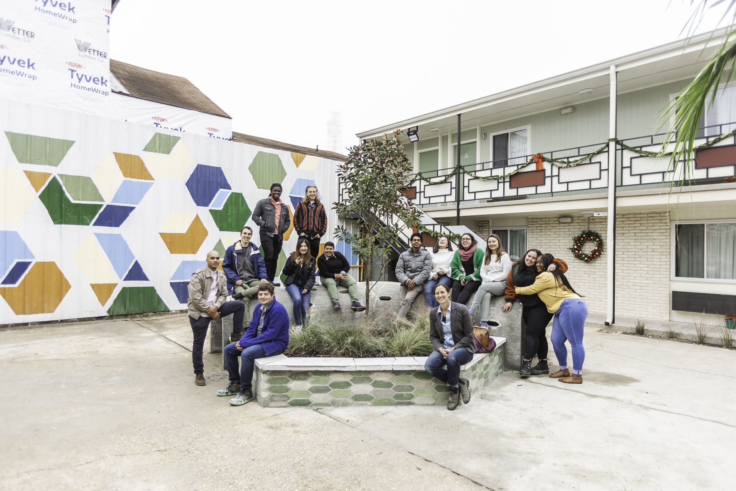 Photo of students and faculty posing around a planter in front of Hotel Hope