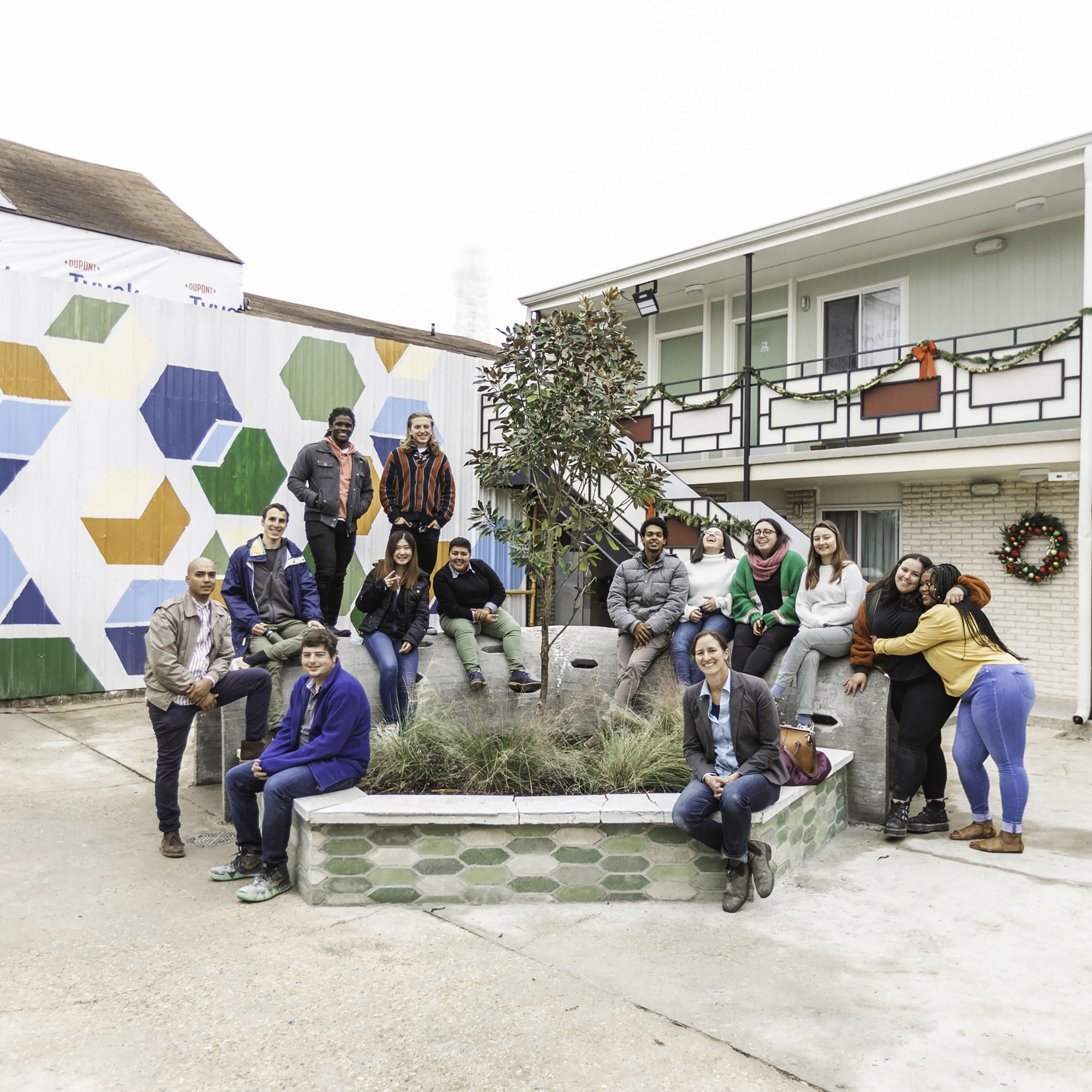 Photo of students and faculty posing around a planter in front of Hotel Hope