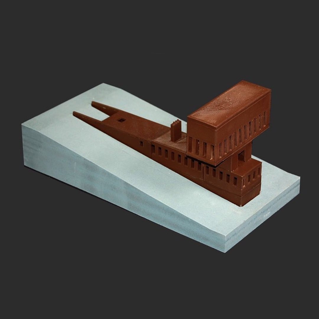 Model of brown "T" house in concrete slab