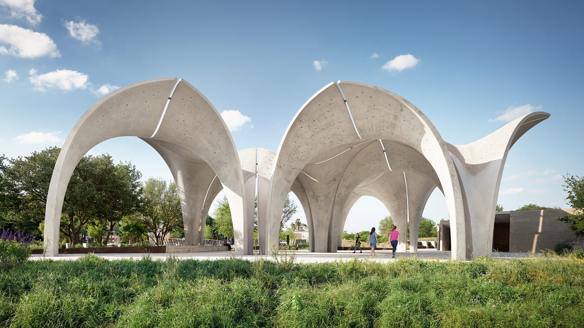 Photo of Confluence park, with greenery in the front of the image and large arches