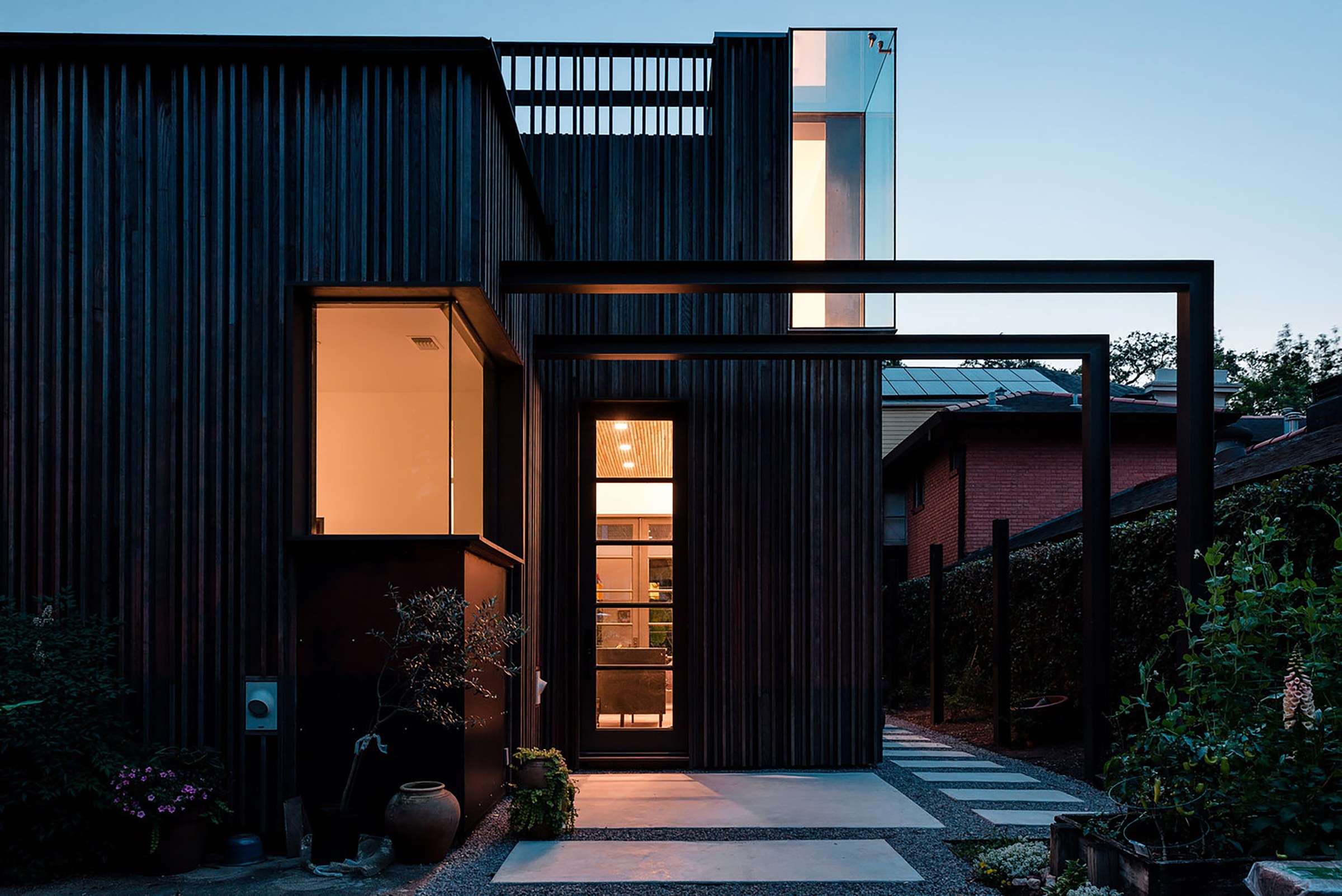 Photo of black contemporary home with two lit windows