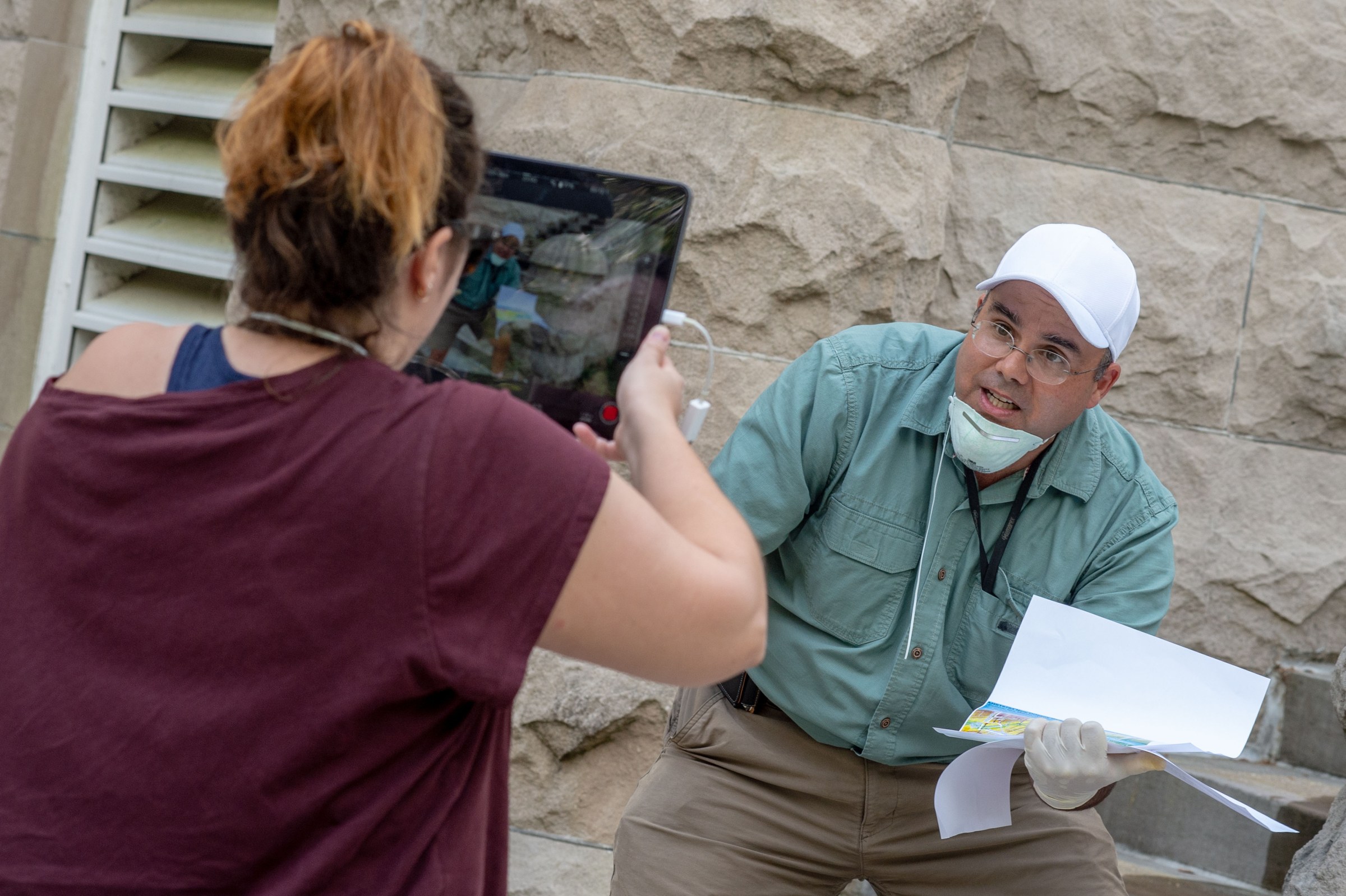 Photo of Professor Campanella explaining something to a woman holding a screen recording him