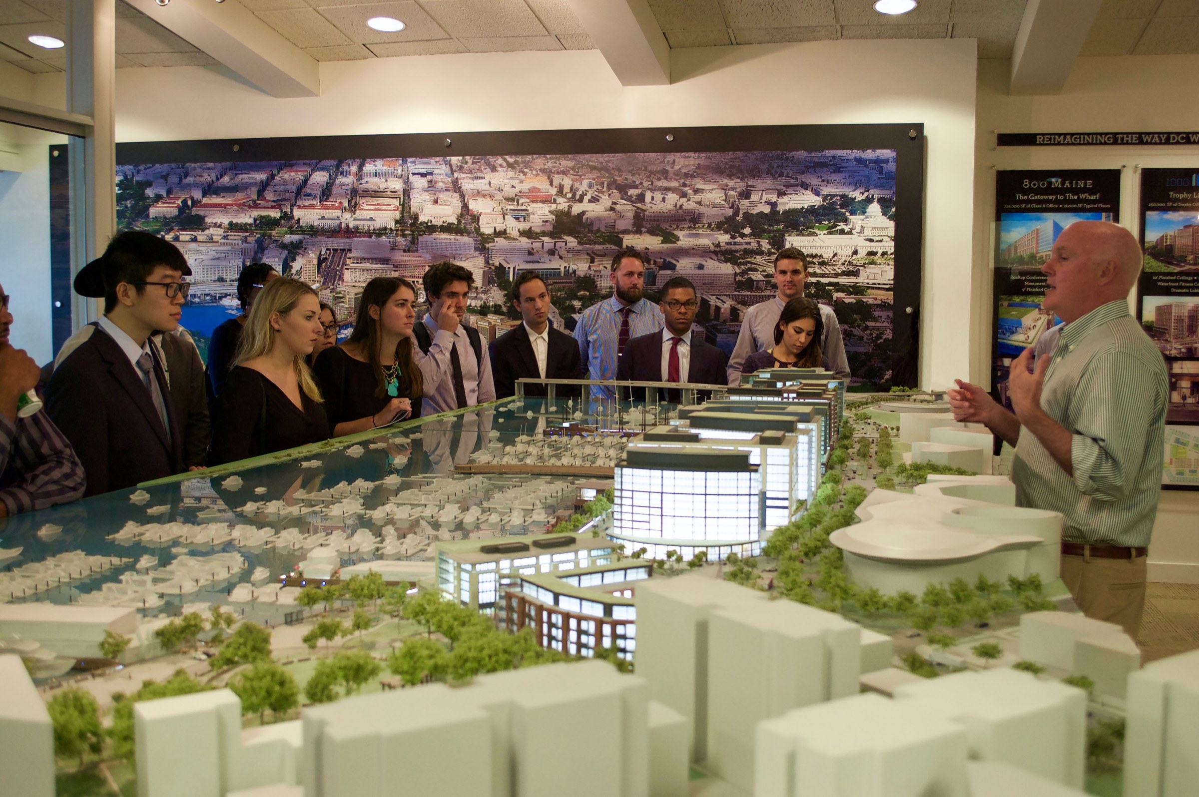 Someone presents to a group of students in front of a model replica