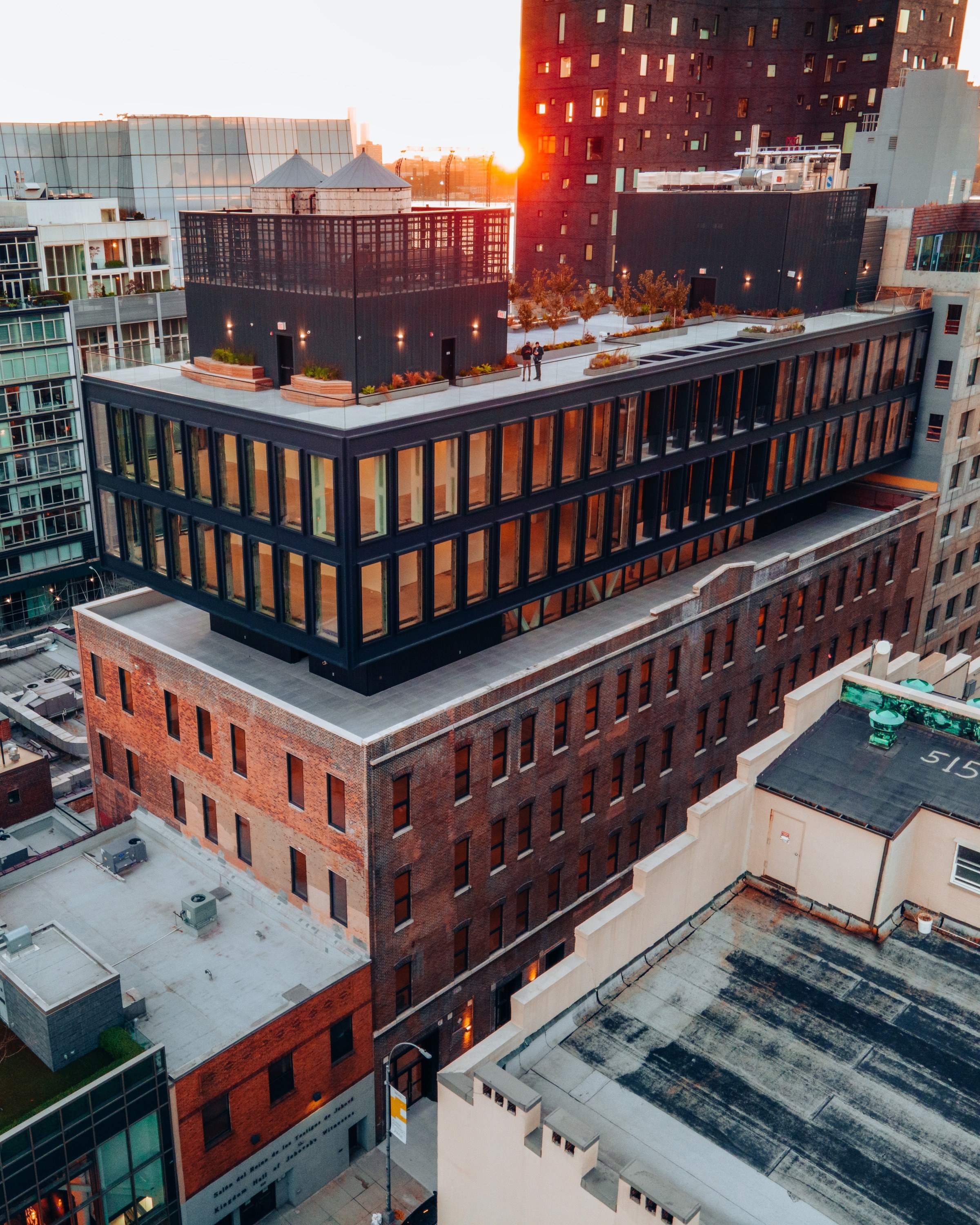 Aerial photo of a modern addition build atop a more historical building in a urban setting.