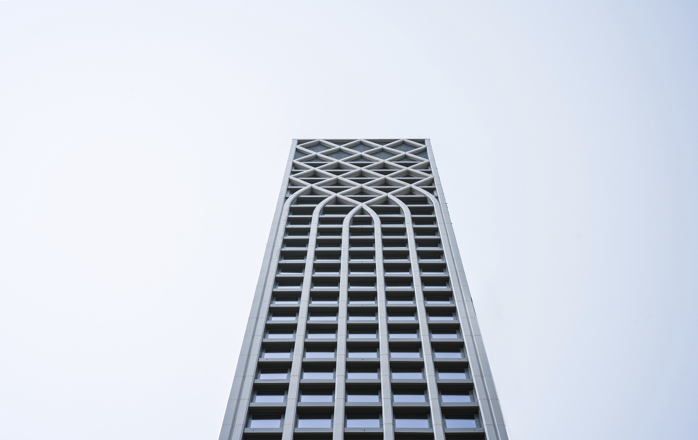 view from ground looking up at the top of a skyscraper's upper floors.