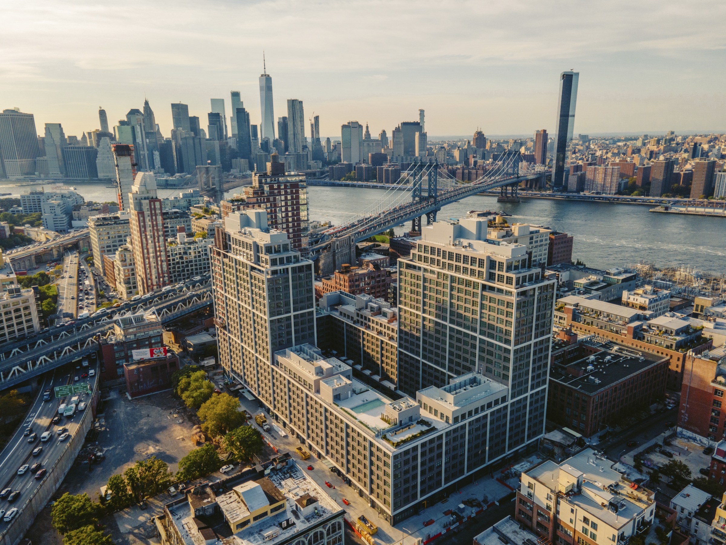 Aerial view of New York City skyline with a large new development spanning several blocks in the foreground.