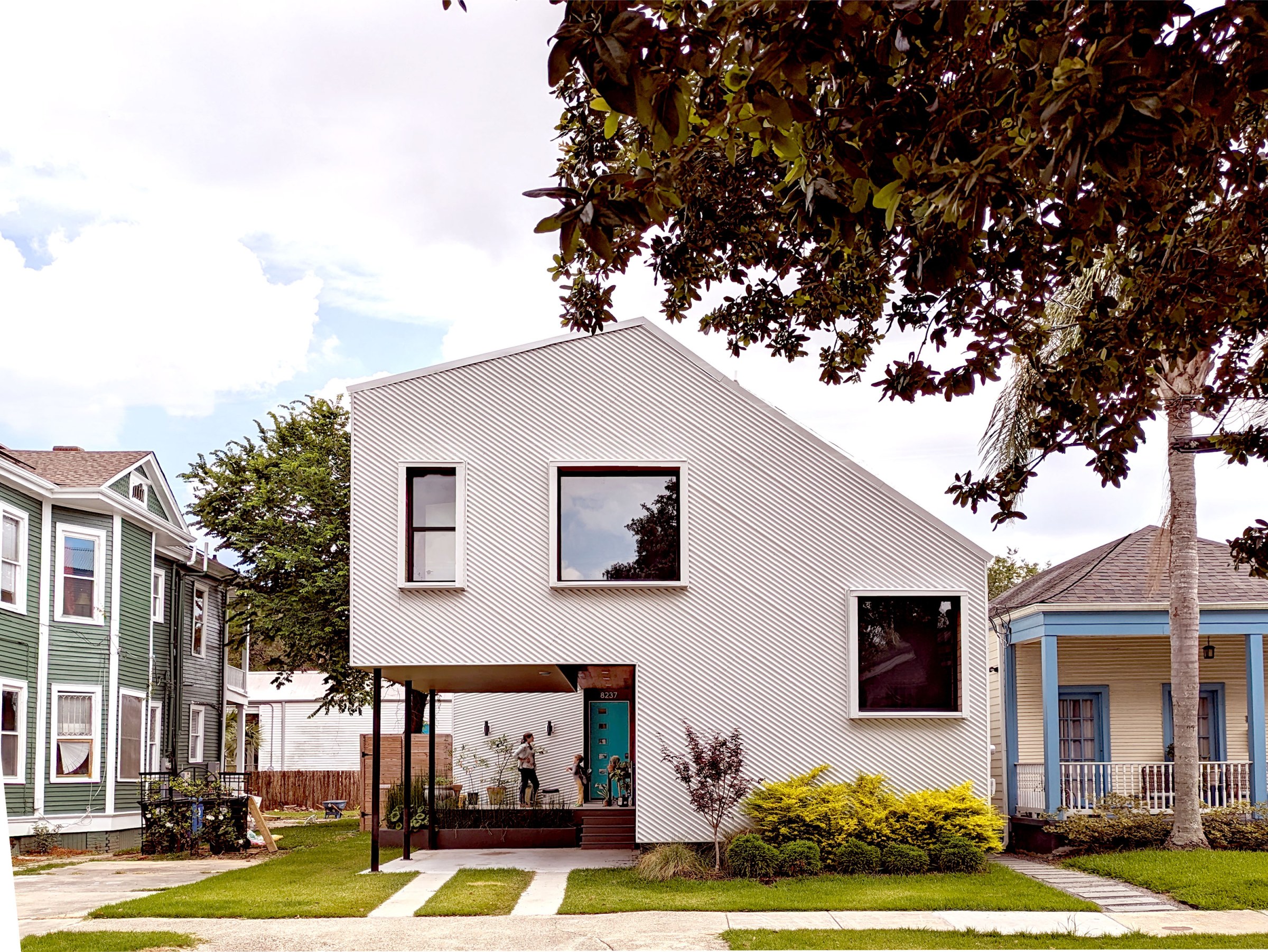 View of the front of a modern style two-story home with a carport built under the left side of the home.