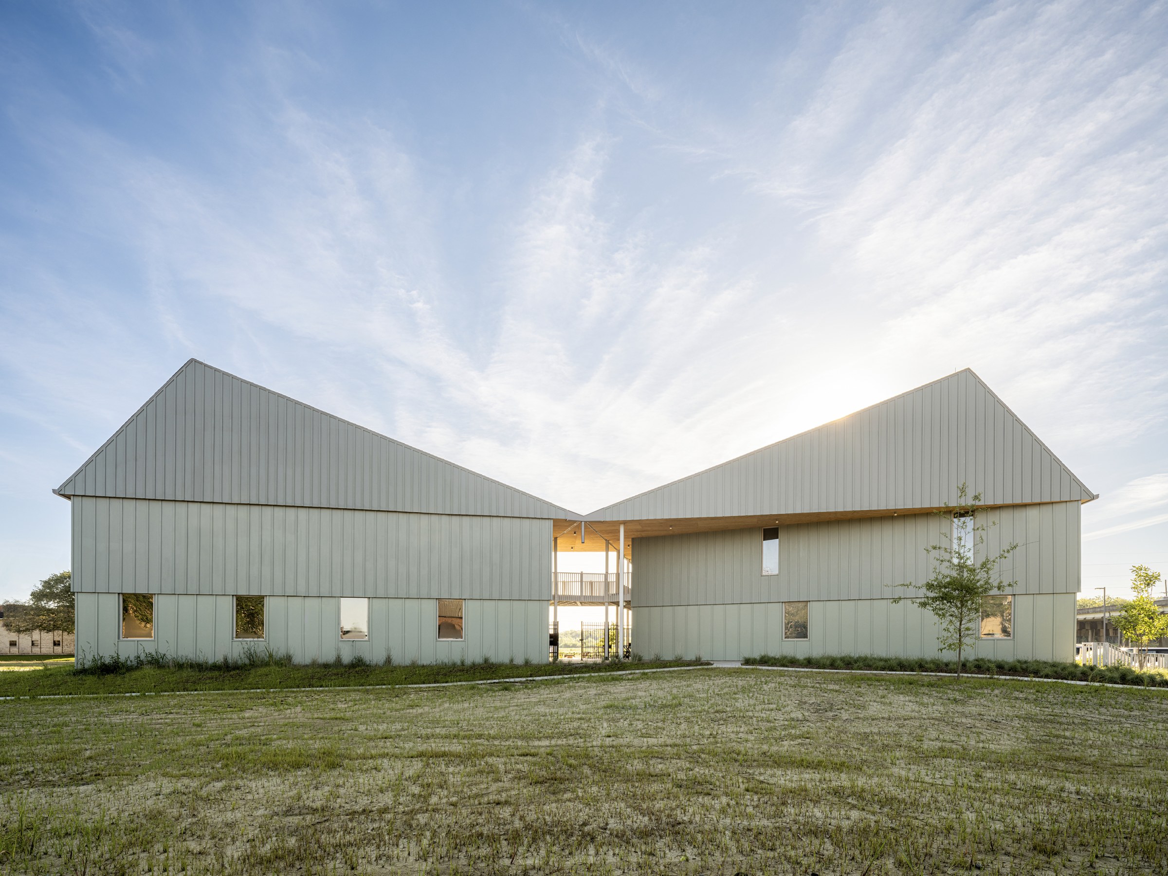 Exterior facade of a modern style multi-family building with an open sky above it.