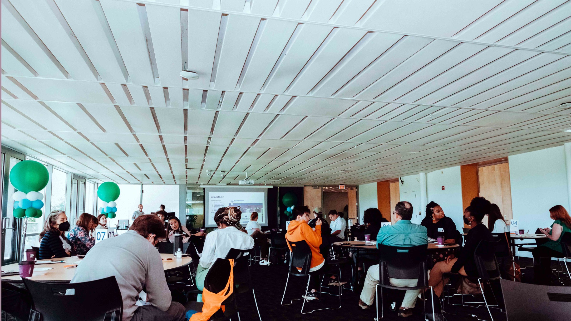 wide shot image of multiple people sitting in a room at an event