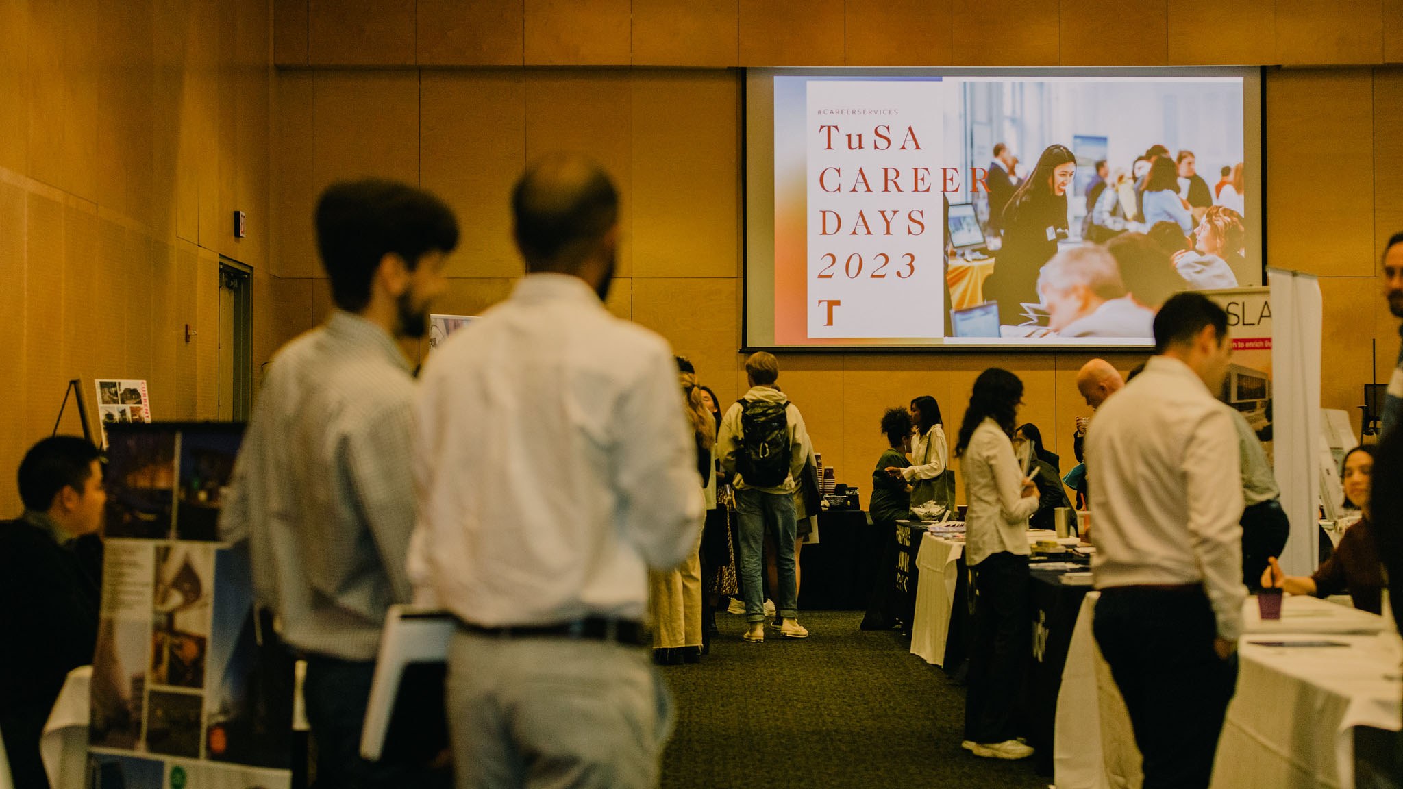 image of the career days 2023 event. wide-shot photo of the screen displaying the title "career days 2023", while people stand in the crowd