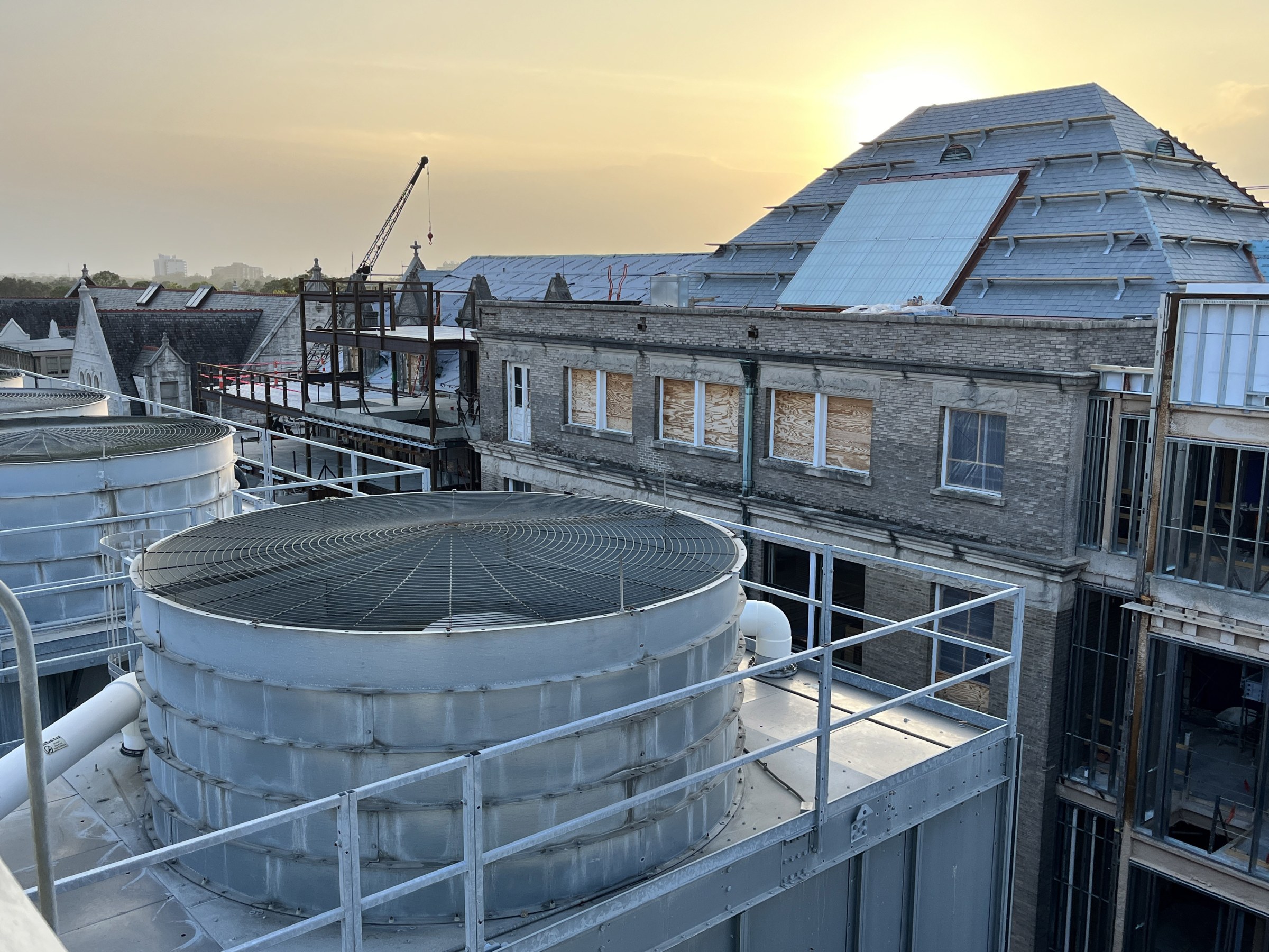 Roof top view of RMH's eastern facade and roof with slate tiles and sunset in the distant background.