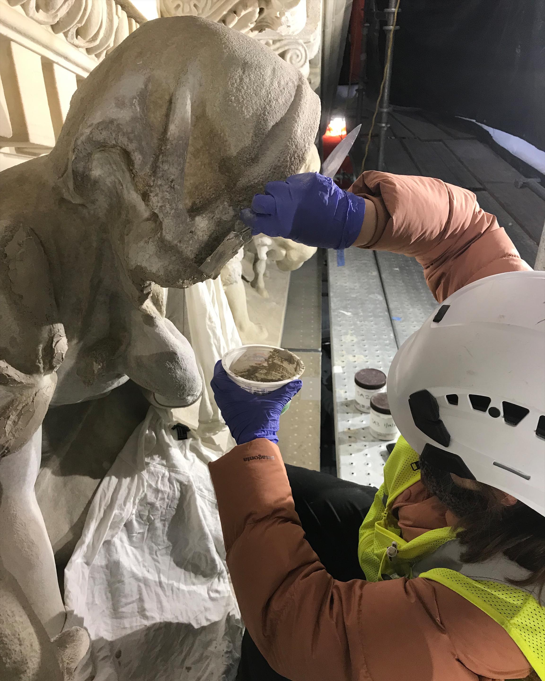 close up image of Emma Kousouris working on a building's facade details